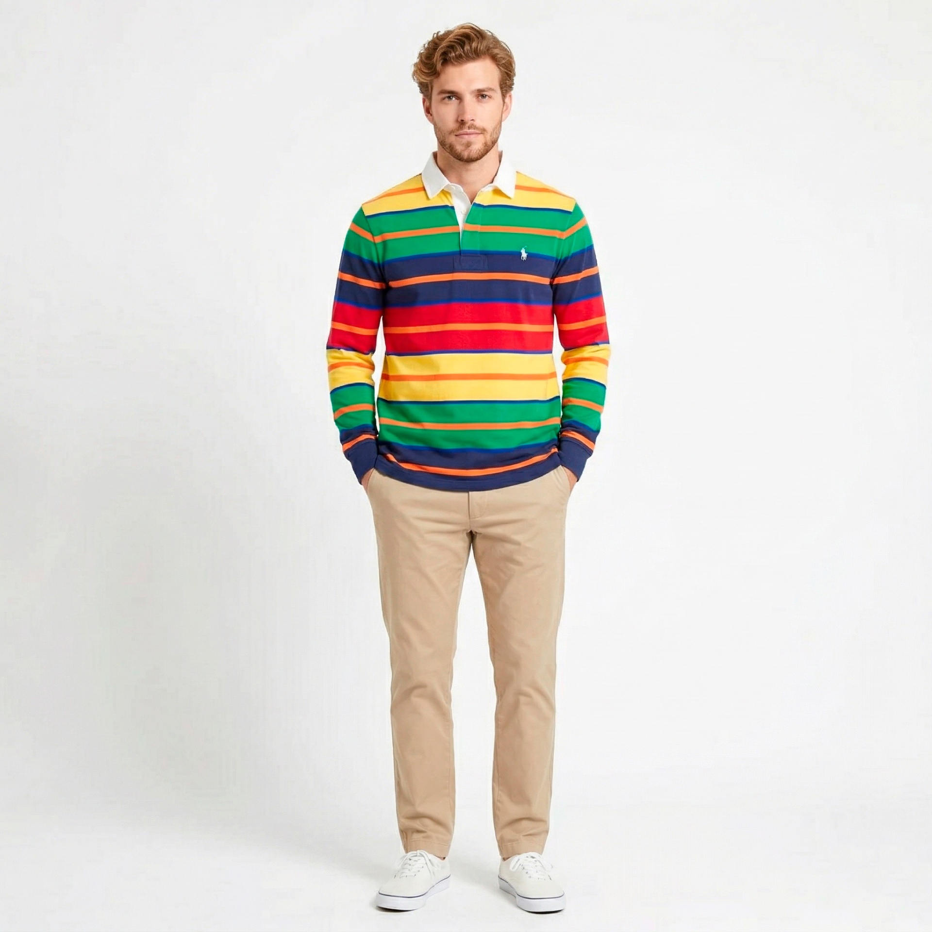 Homem com polo de riscas coloridas, calças bege e ténis brancos, fundo branco.