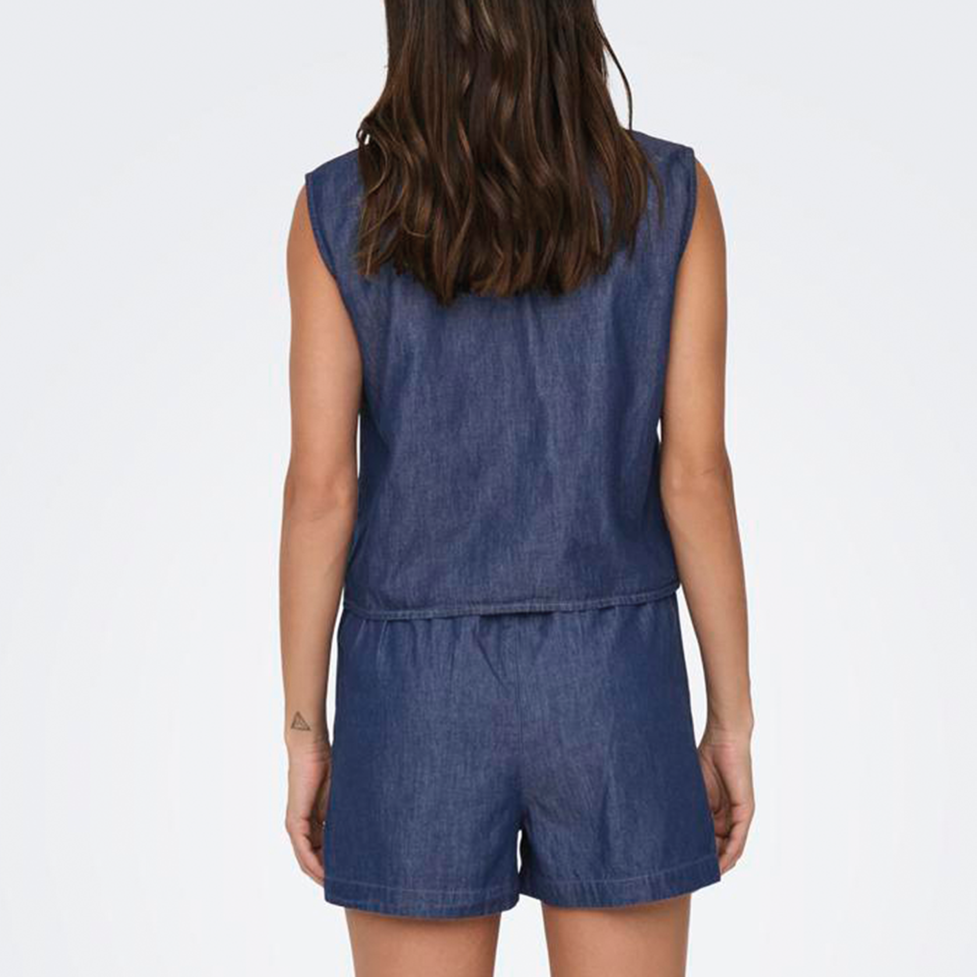 Macacão curto azul em denim visto de costas