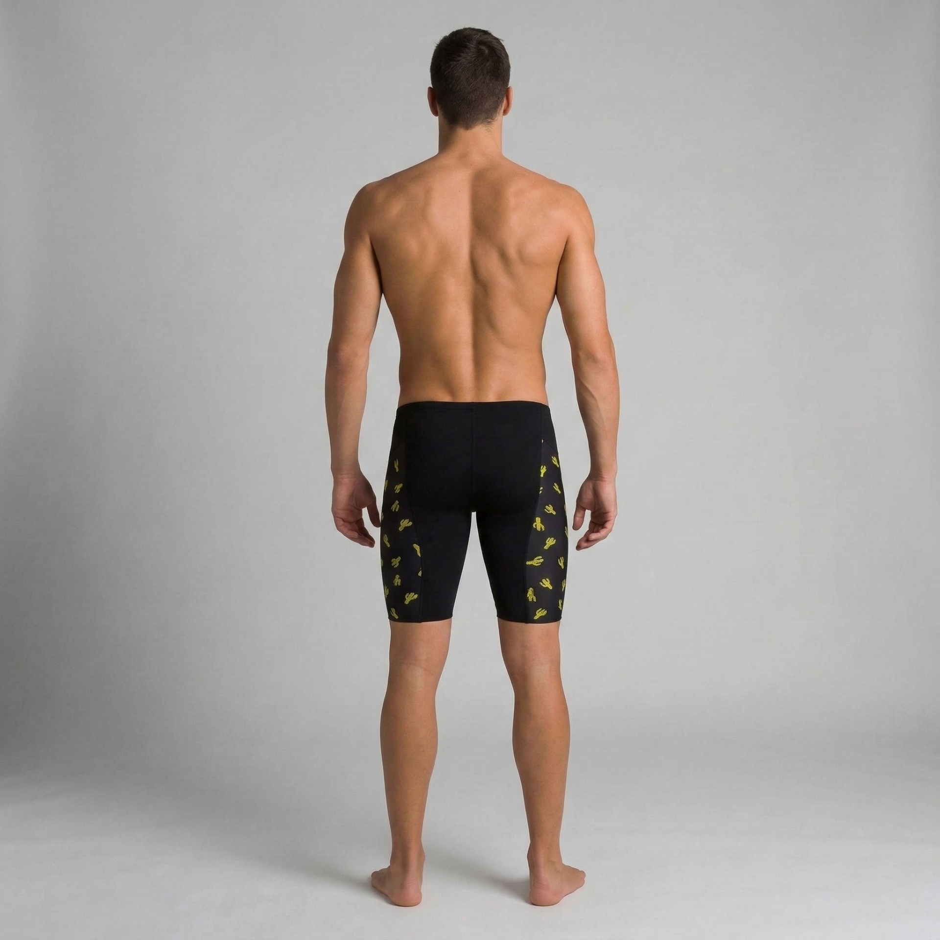 Homem de costas com calções desportivos pretos e padrão amarelo de cactos