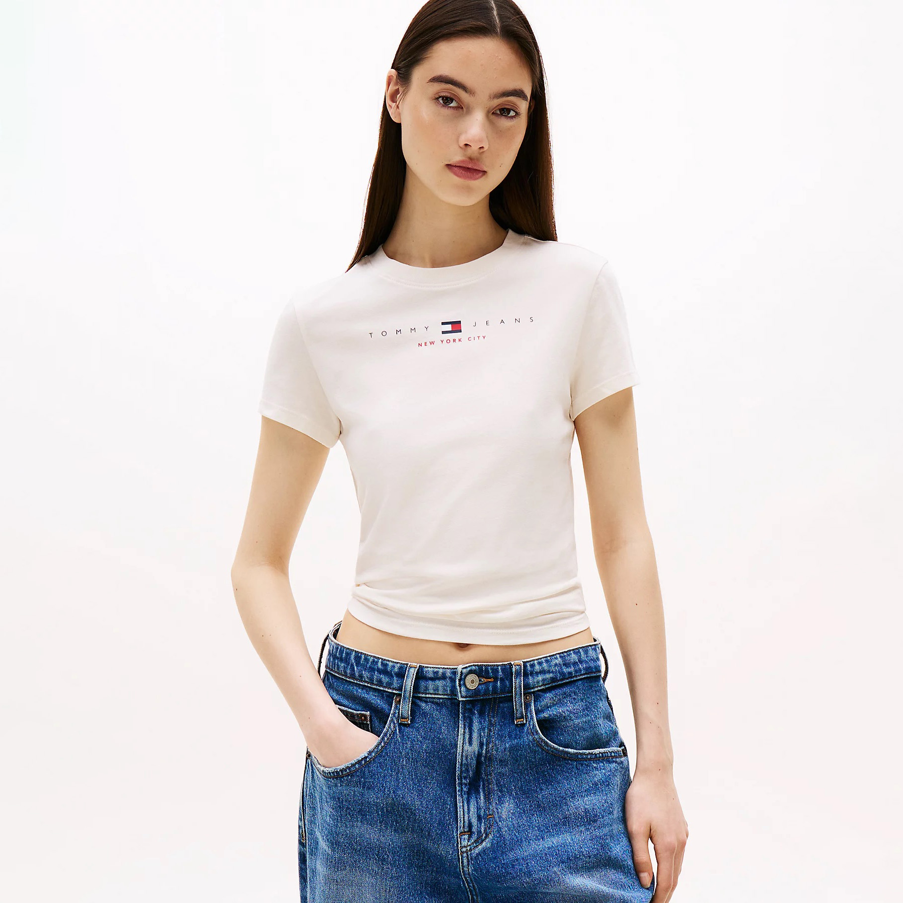 T-shirt branca com texto Tommy Jeans e jeans azuis