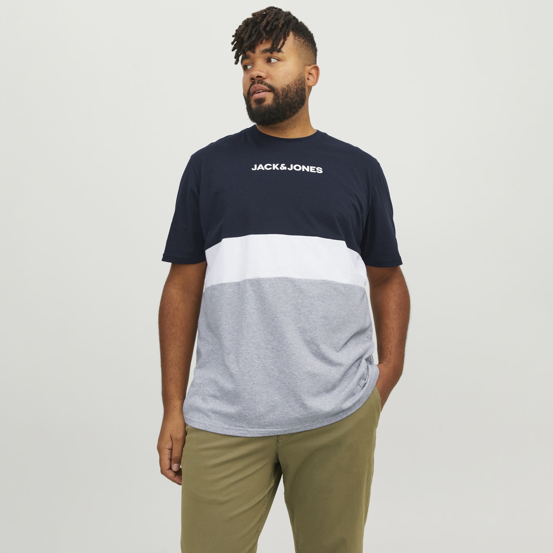 Homem com t-shirt tricolor JACK & JONES e calças castanhas claras