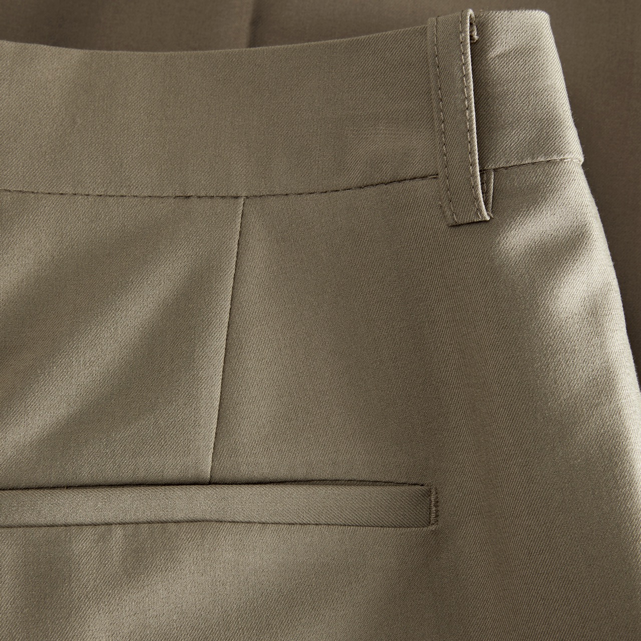 Calças castanhas com bolso traseiro e cinto.