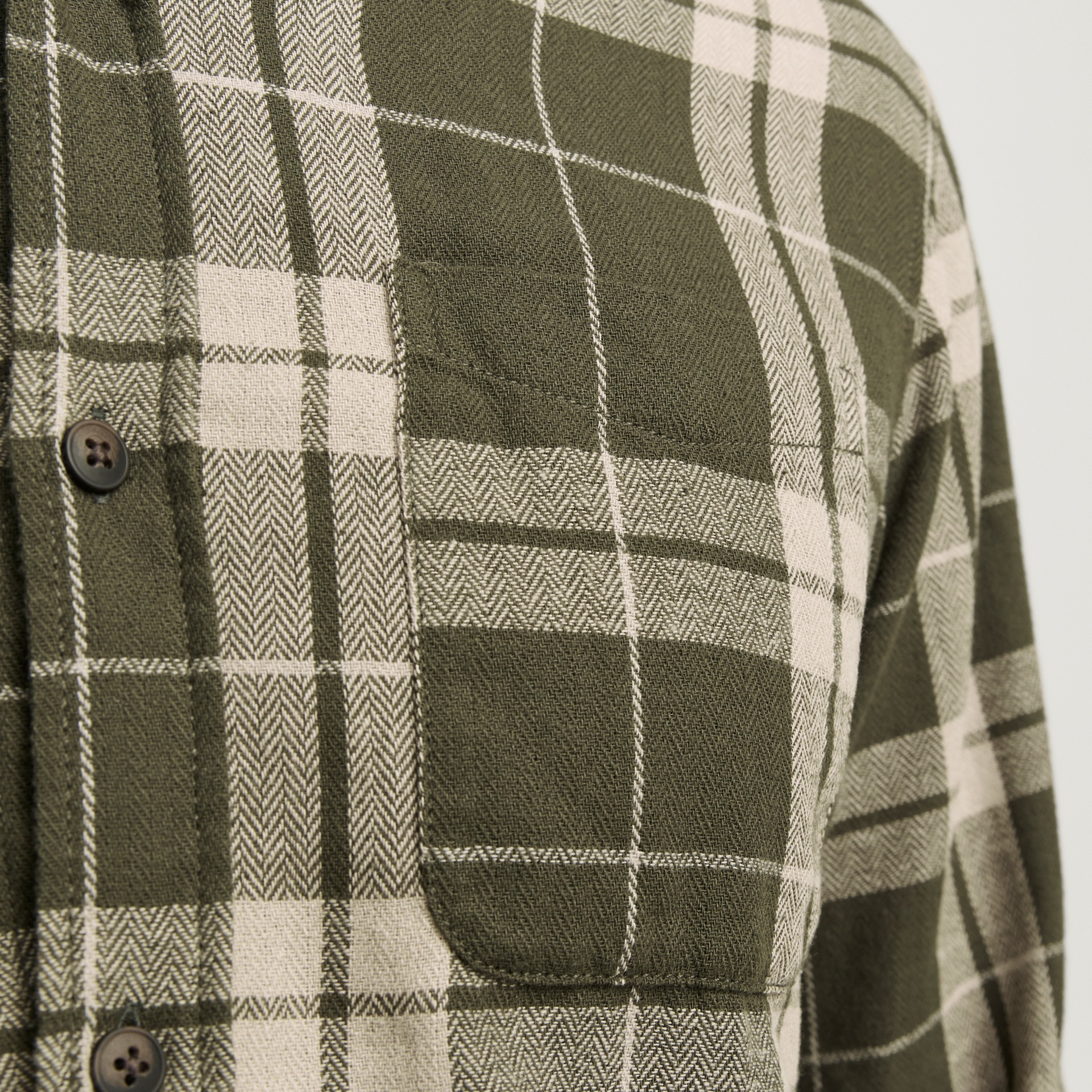 Camisa xadrez verde e bege com bolso frontal e botões pretos