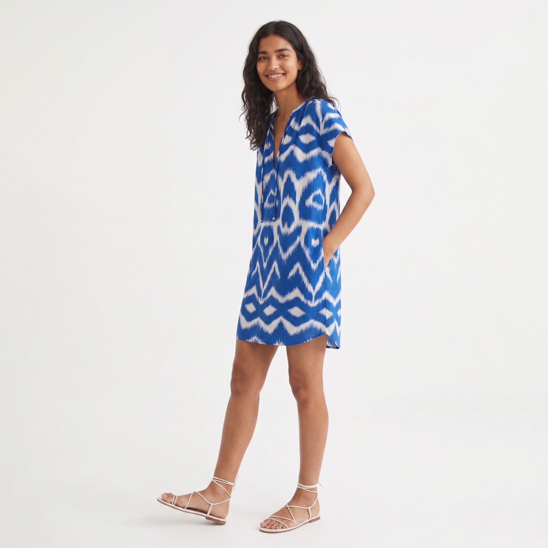 Vestido curto azul e branco com padrão zig-zag, usado por mulher.