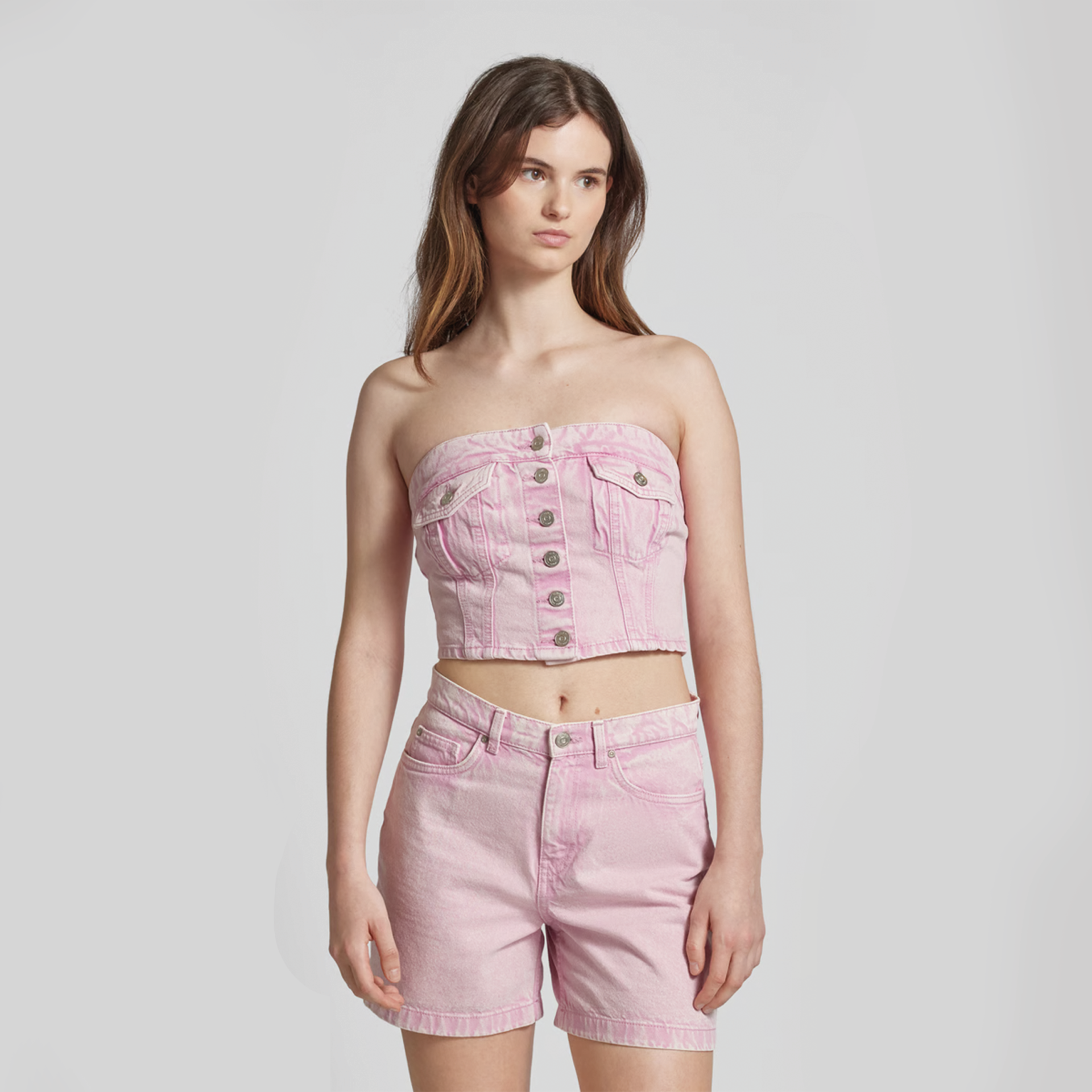 Conjunto feminino rosa claro com top bustiê e calções de ganga com botões metálicos