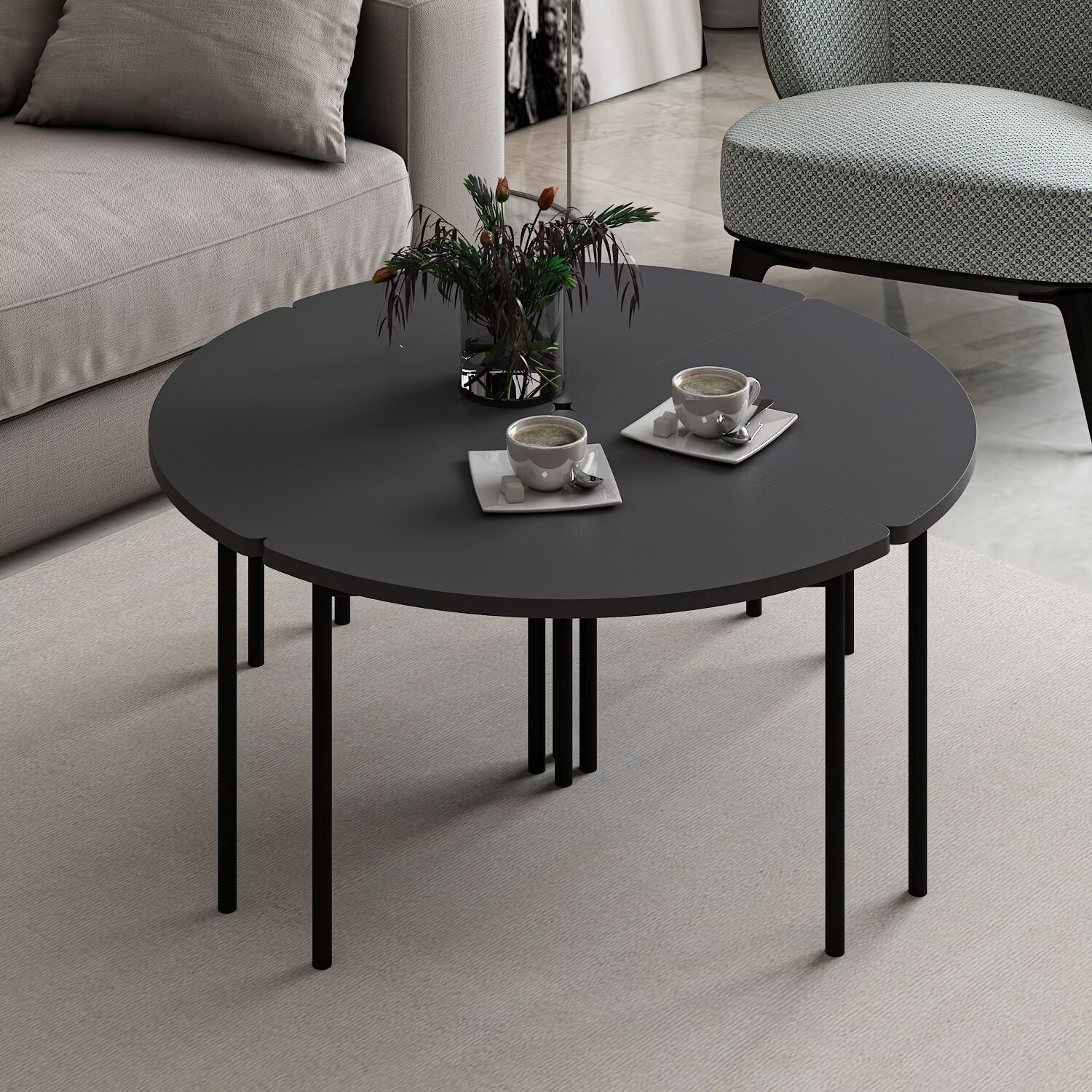 Mesa de centro redonda preta com duas chávenas de café e arranjo floral