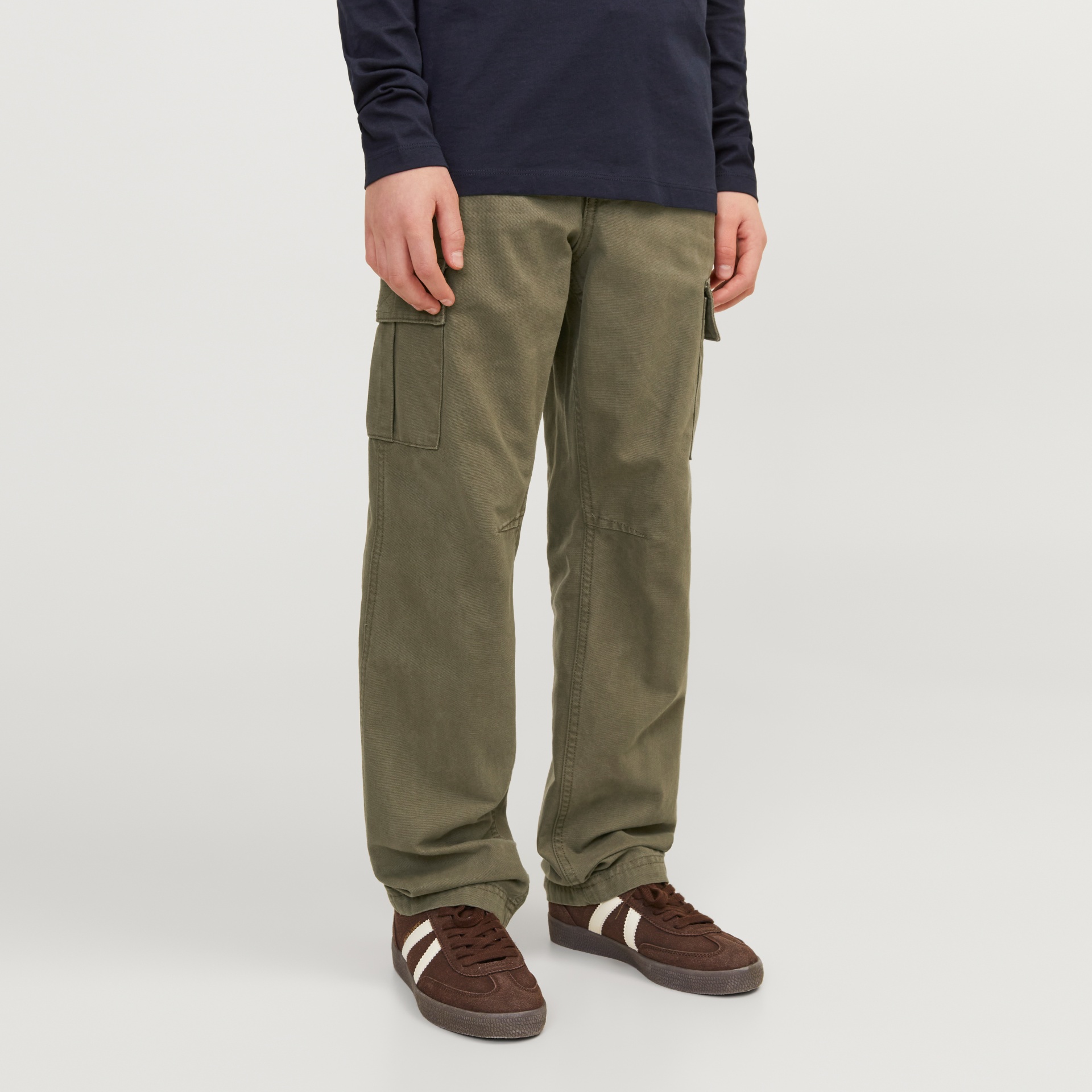 Calças cargo verdes usadas com sapatilhas castanhas e camiseta azul escuro