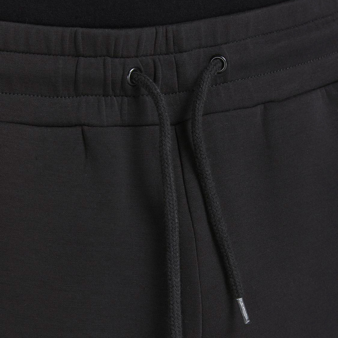 Calças de ganga pretas com cordões e ilhóses metálicos