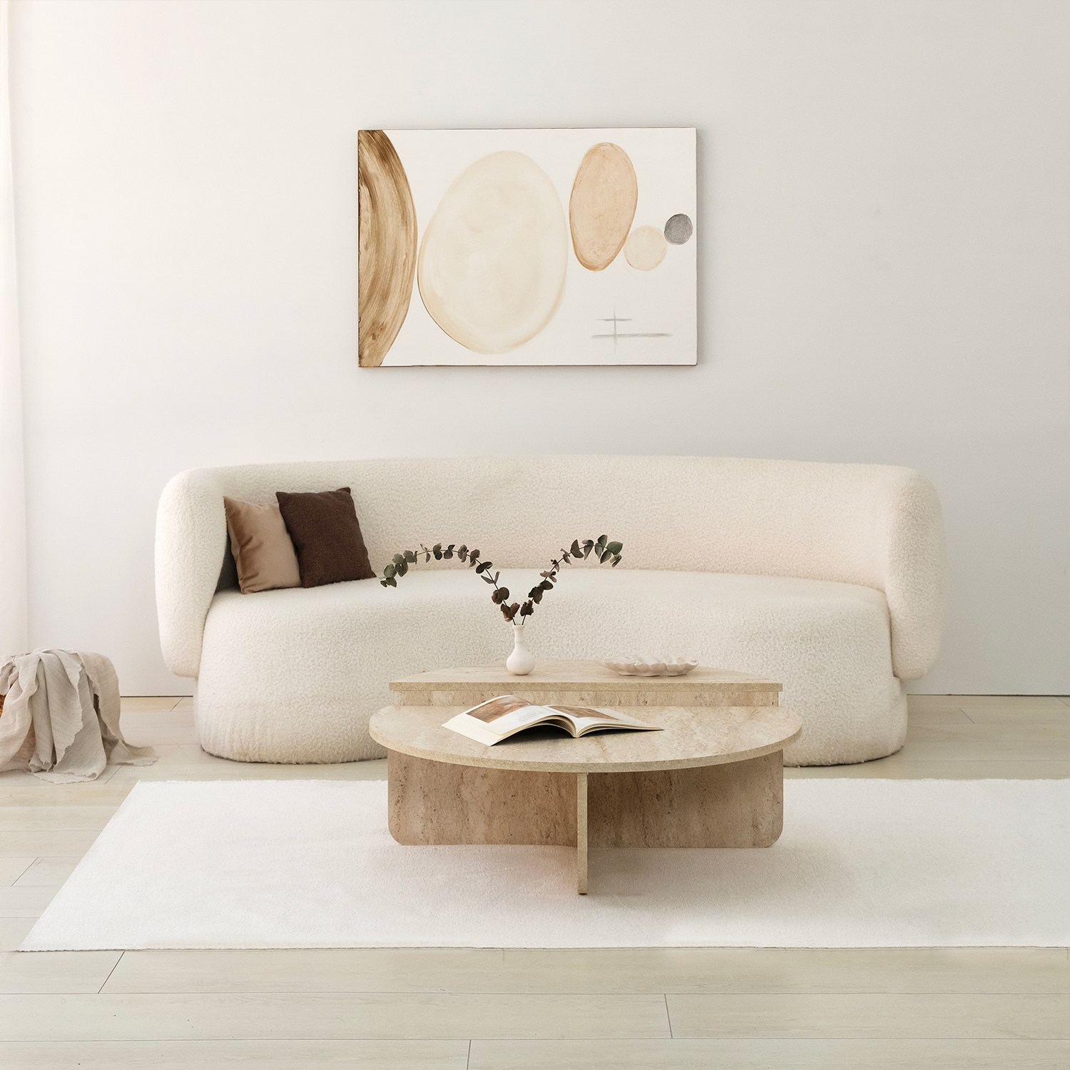 Sofá branco curvo com mesa de centro em pedra e decoração minimalista