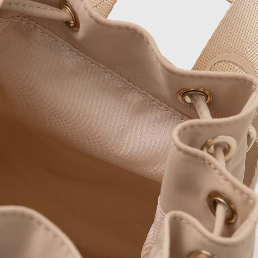 Interior de mala bege clara com argolas metálicas douradas e cordão de fechamento