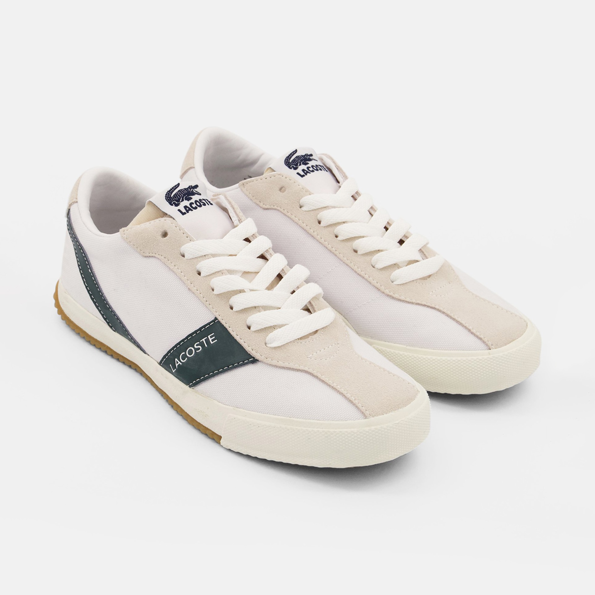 Sapatilhas Lacoste brancas com detalhes bege e faixa verde-escura.