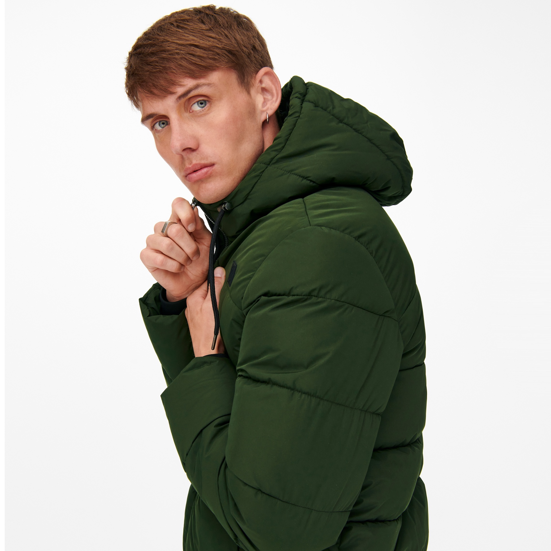 Homem com casaco verde escuro acolchoado com capuz ajustando o fecho