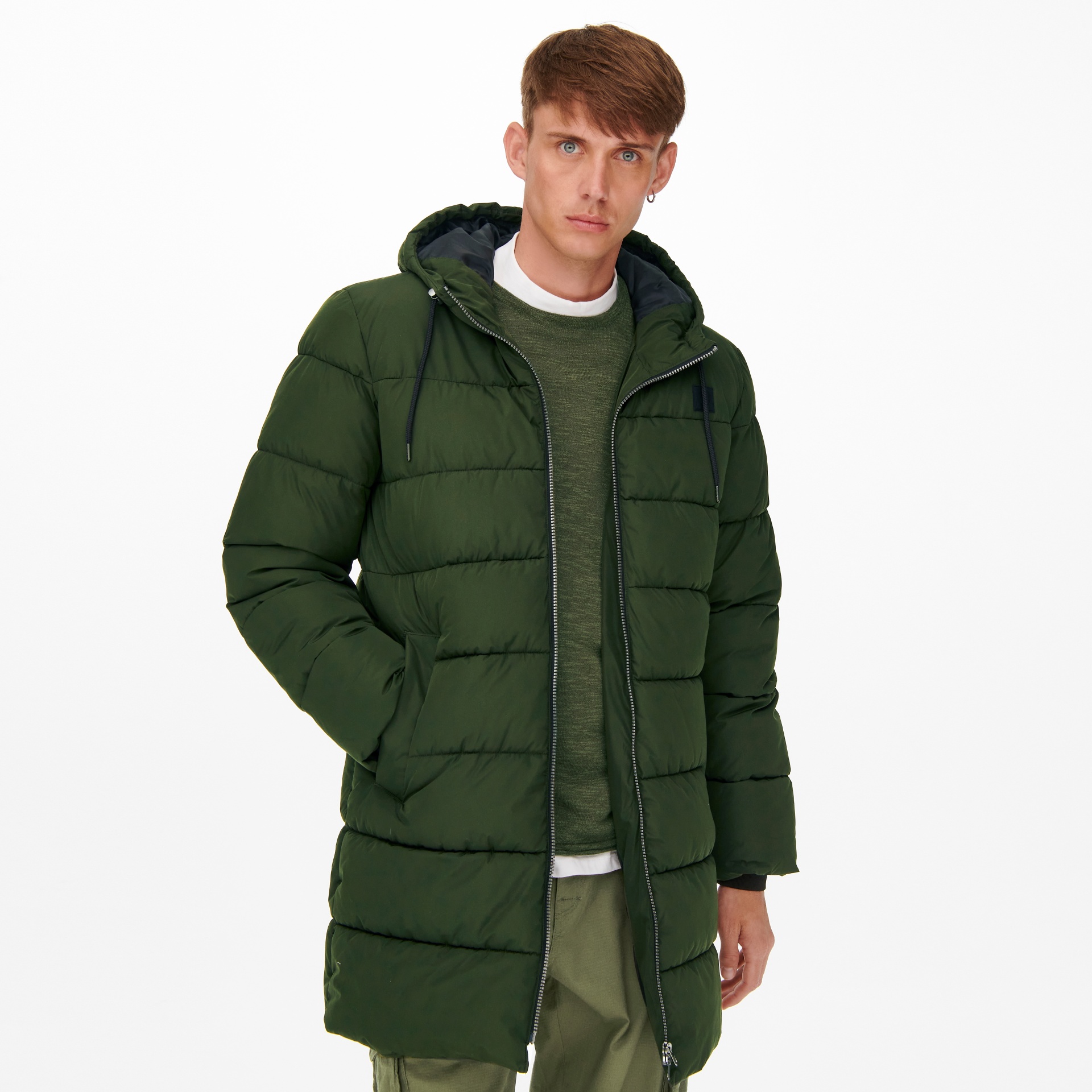 Homem com casaco acolchoado verde escuro com capuz e fecho de correr em fundo branco