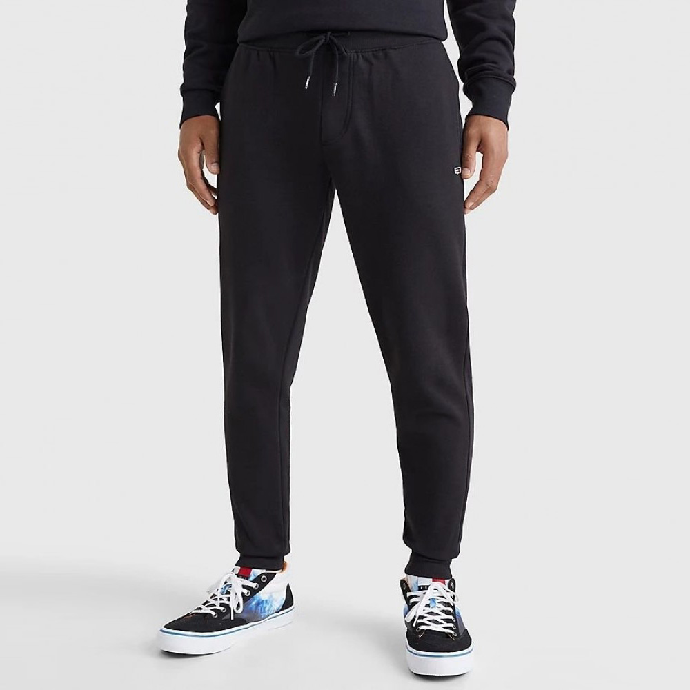 Calças de treino pretas com cordão e ténis pretos, brancos e azuis