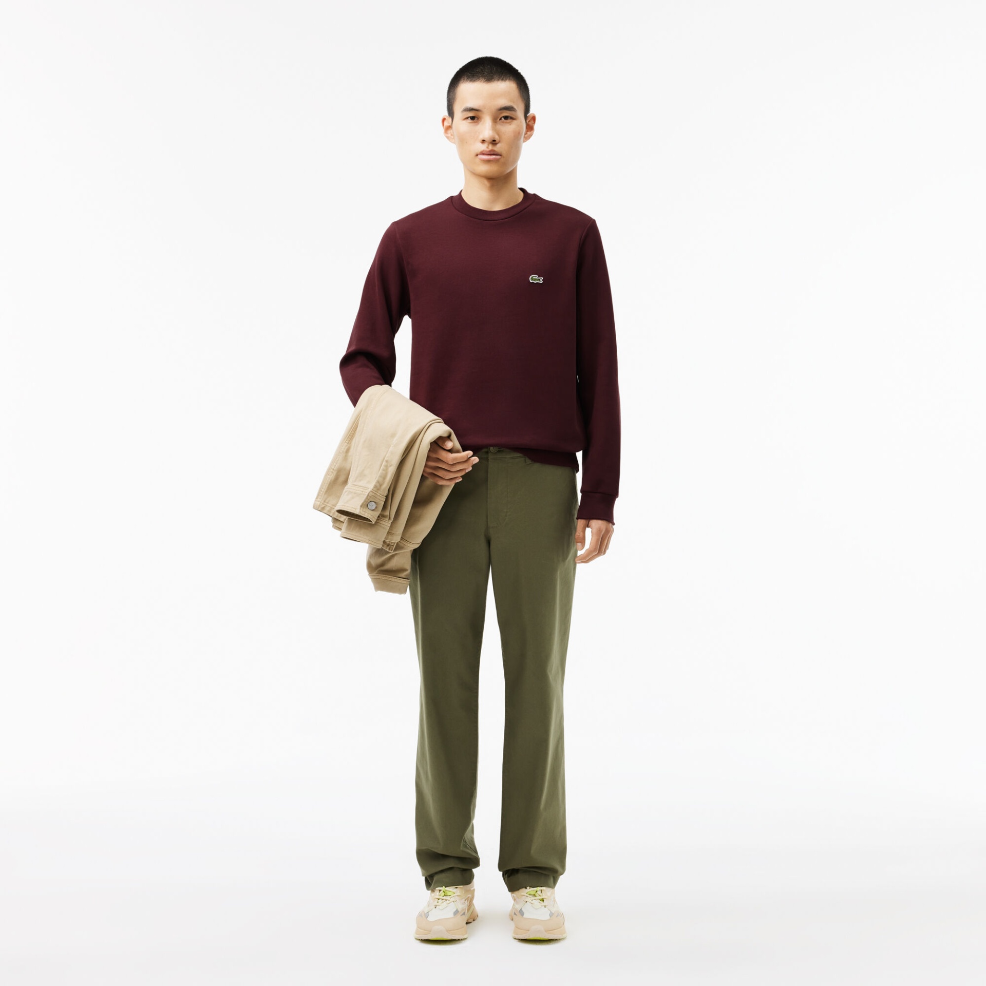 Homem com roupa casual, roupa em bordeaux e verde, fundo branco.