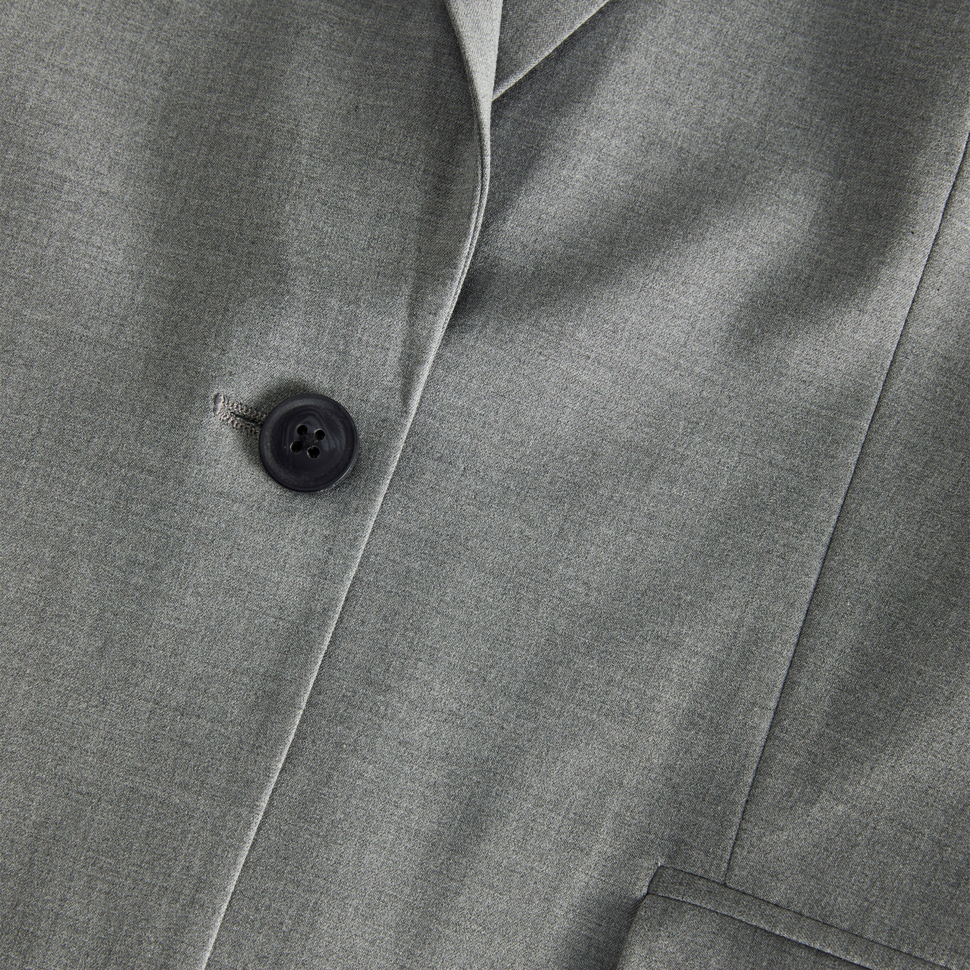 Casaco cinzento com botão preto e tecido liso