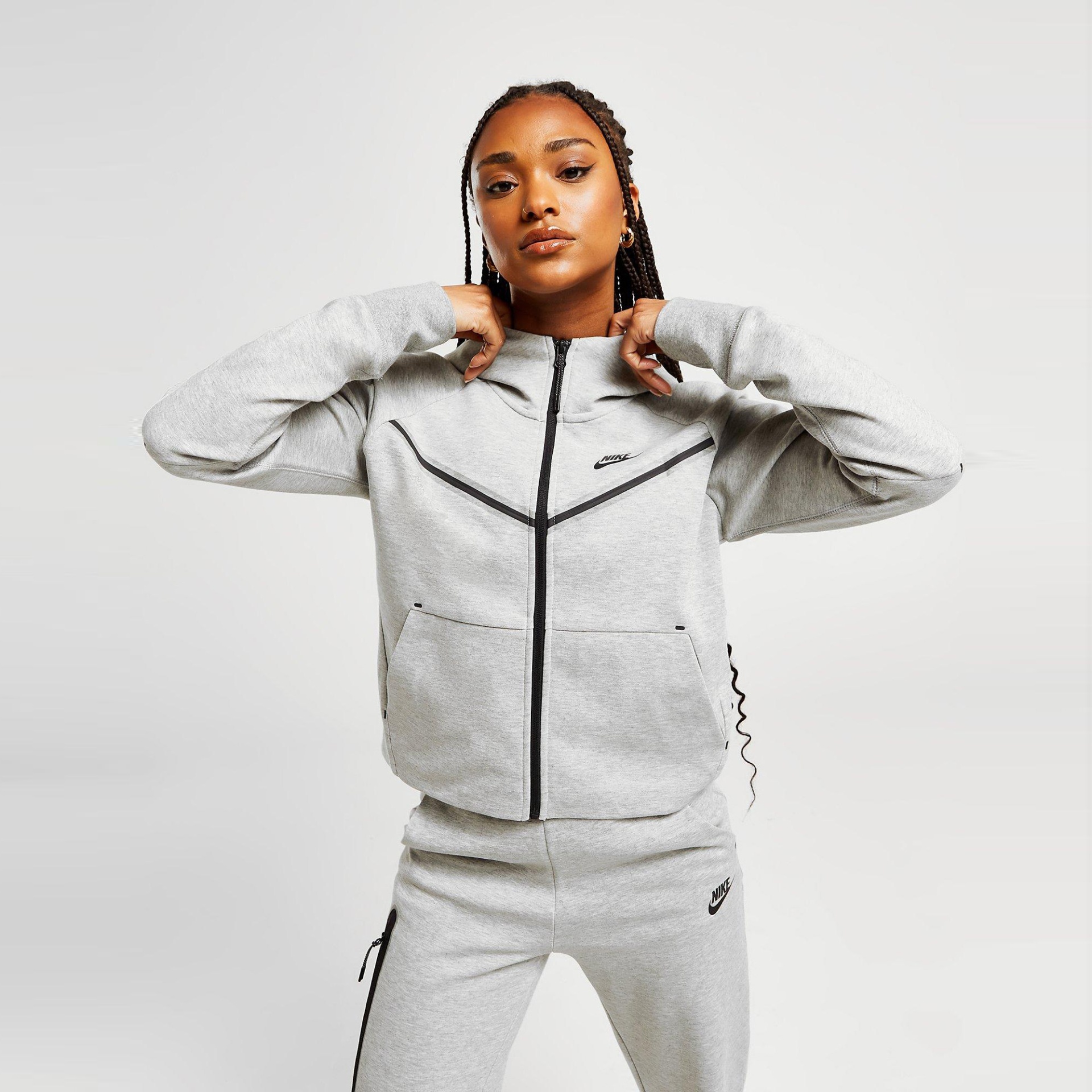 Conjunto de roupa desportiva cinzenta da marca Nike com casaco e calças.