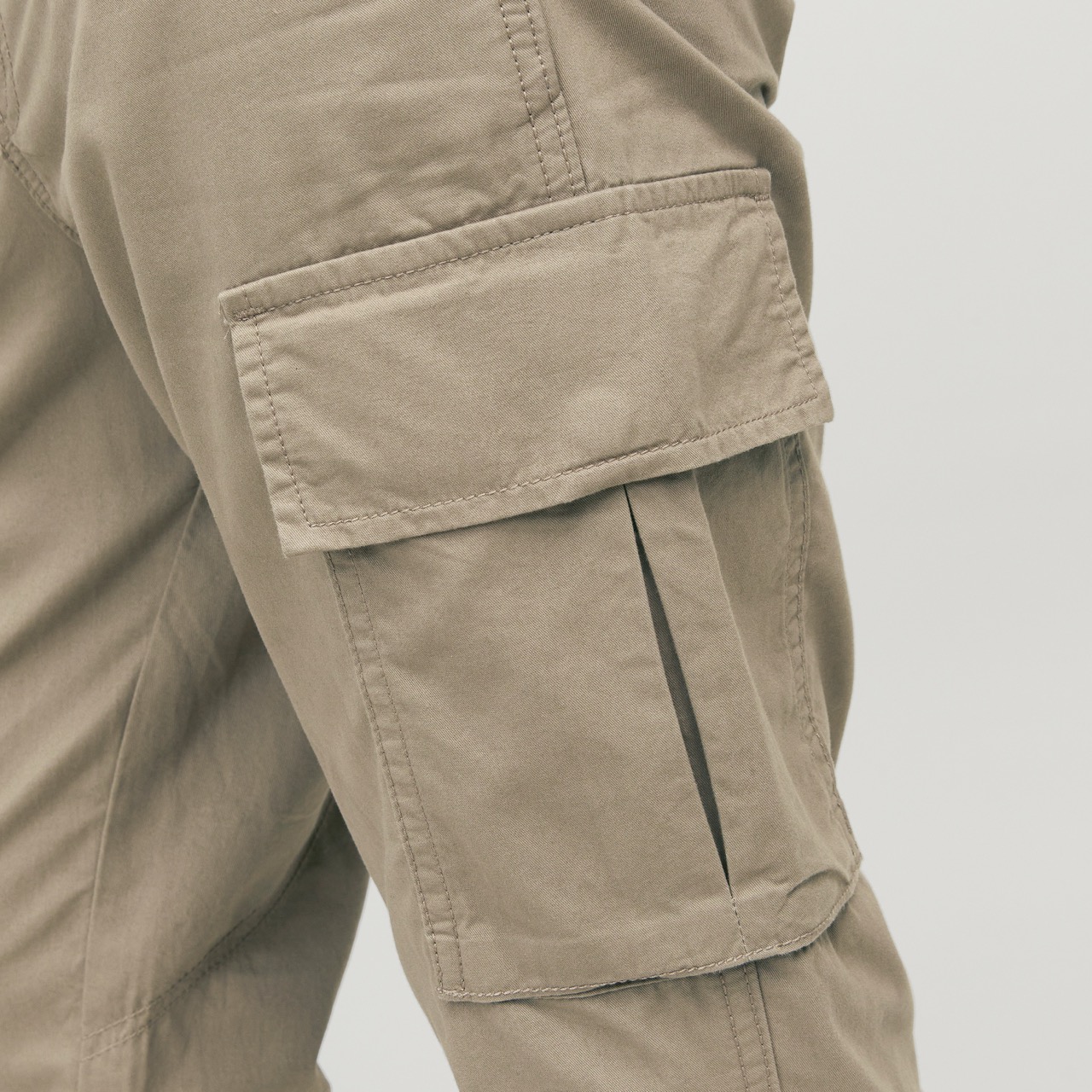 Calças cargo bege com bolso grande no lado da perna