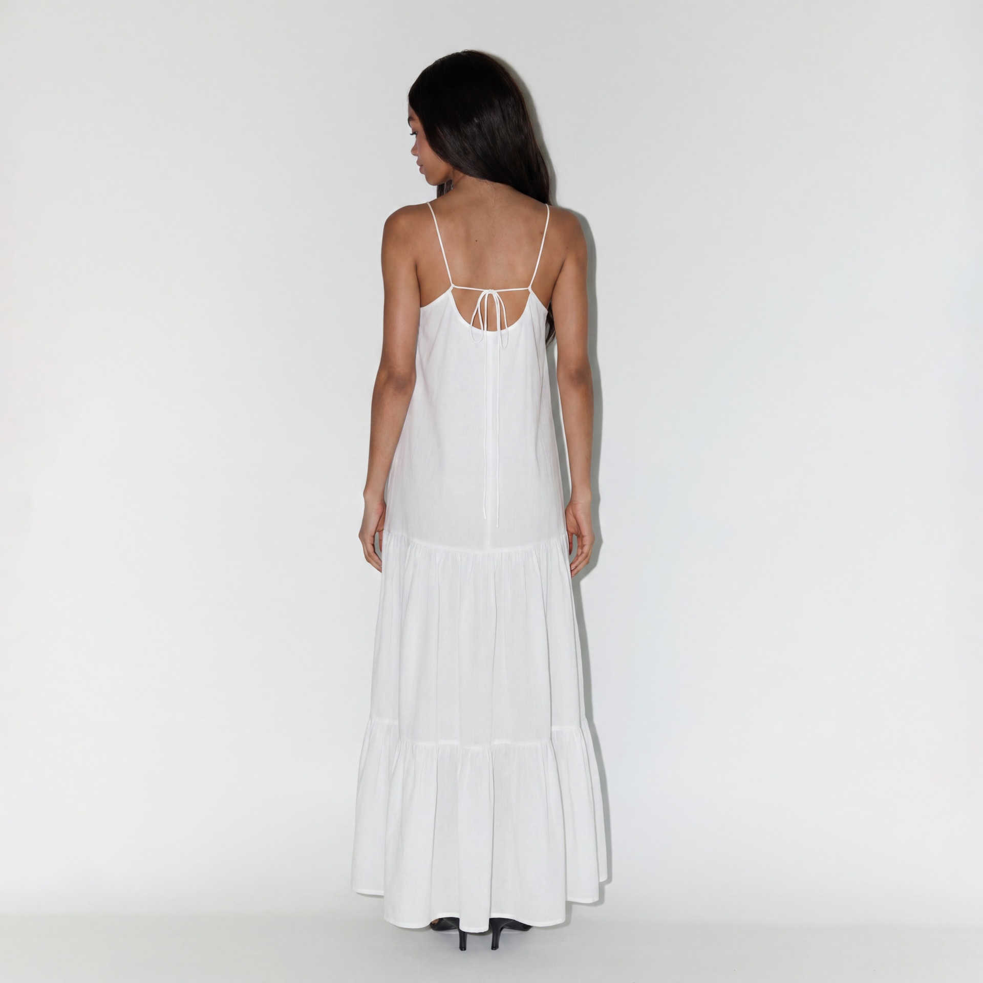 Vestido branco comprido de alças finas com laço nas costas visto por trás