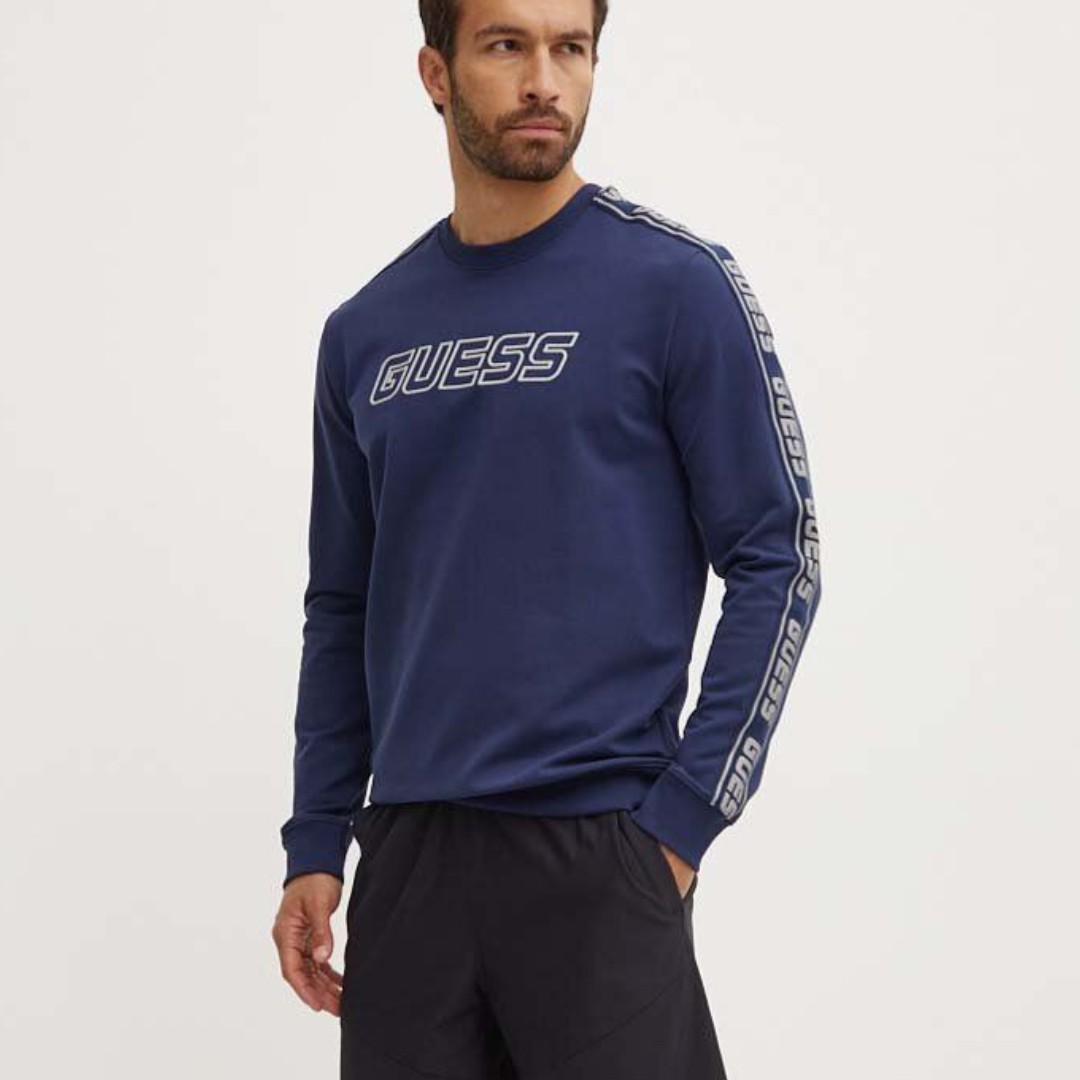 Camisola azul escura GUESS com logótipos em branco usada por homem