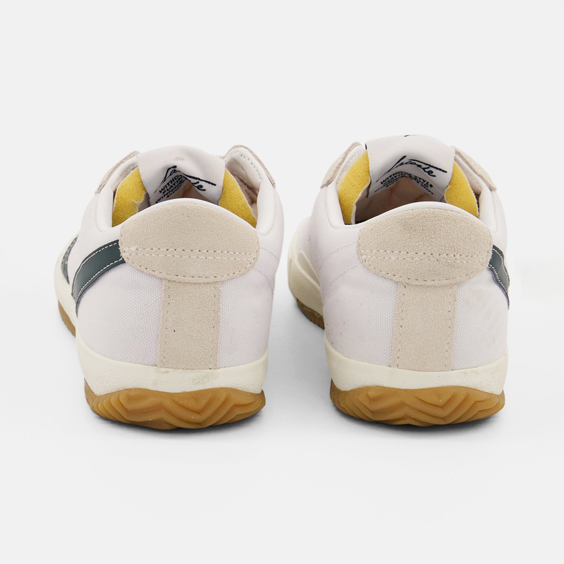 Sapatilhas brancas com sola castanha vistas de costas