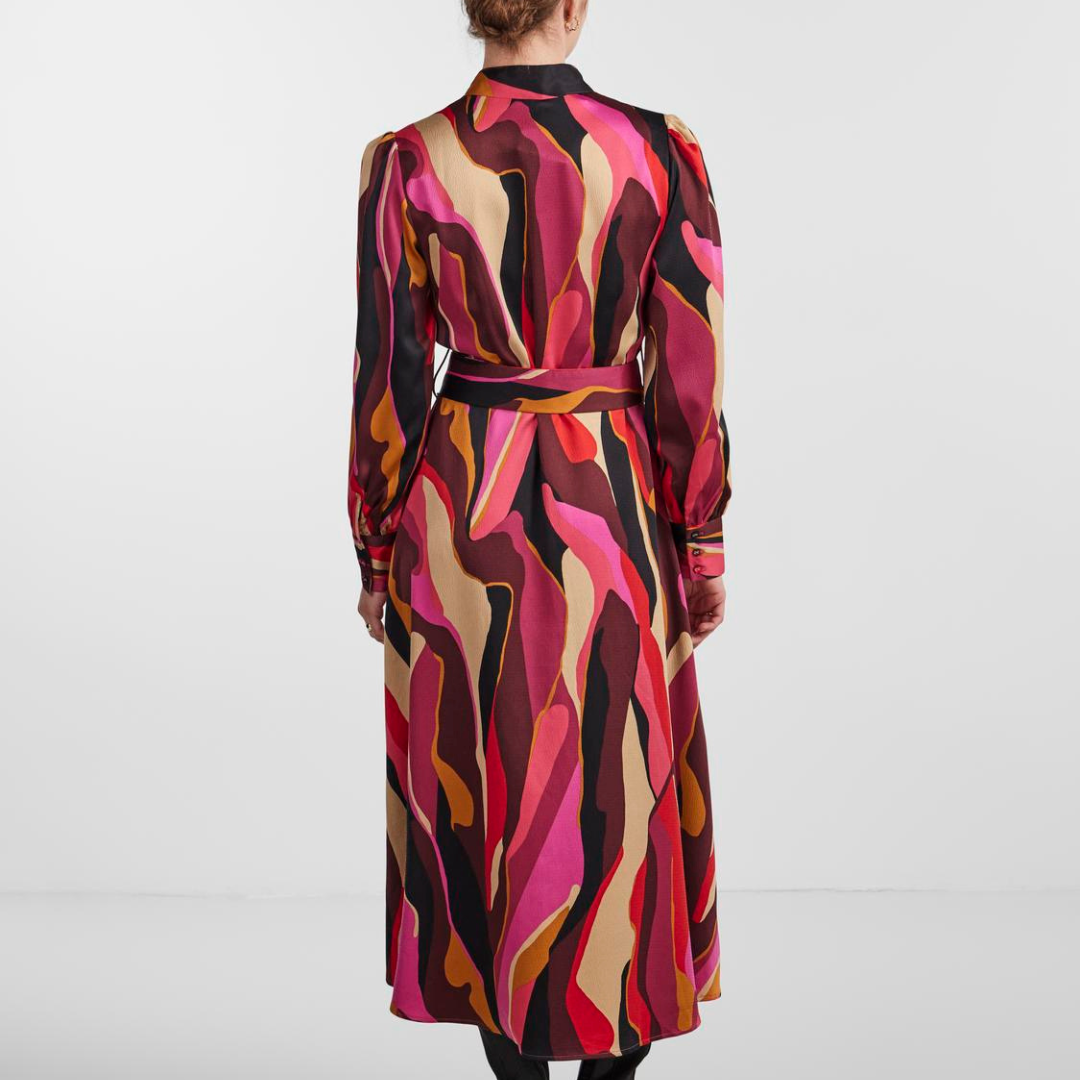 Vestido comprido com padrão colorido, visto de costas.