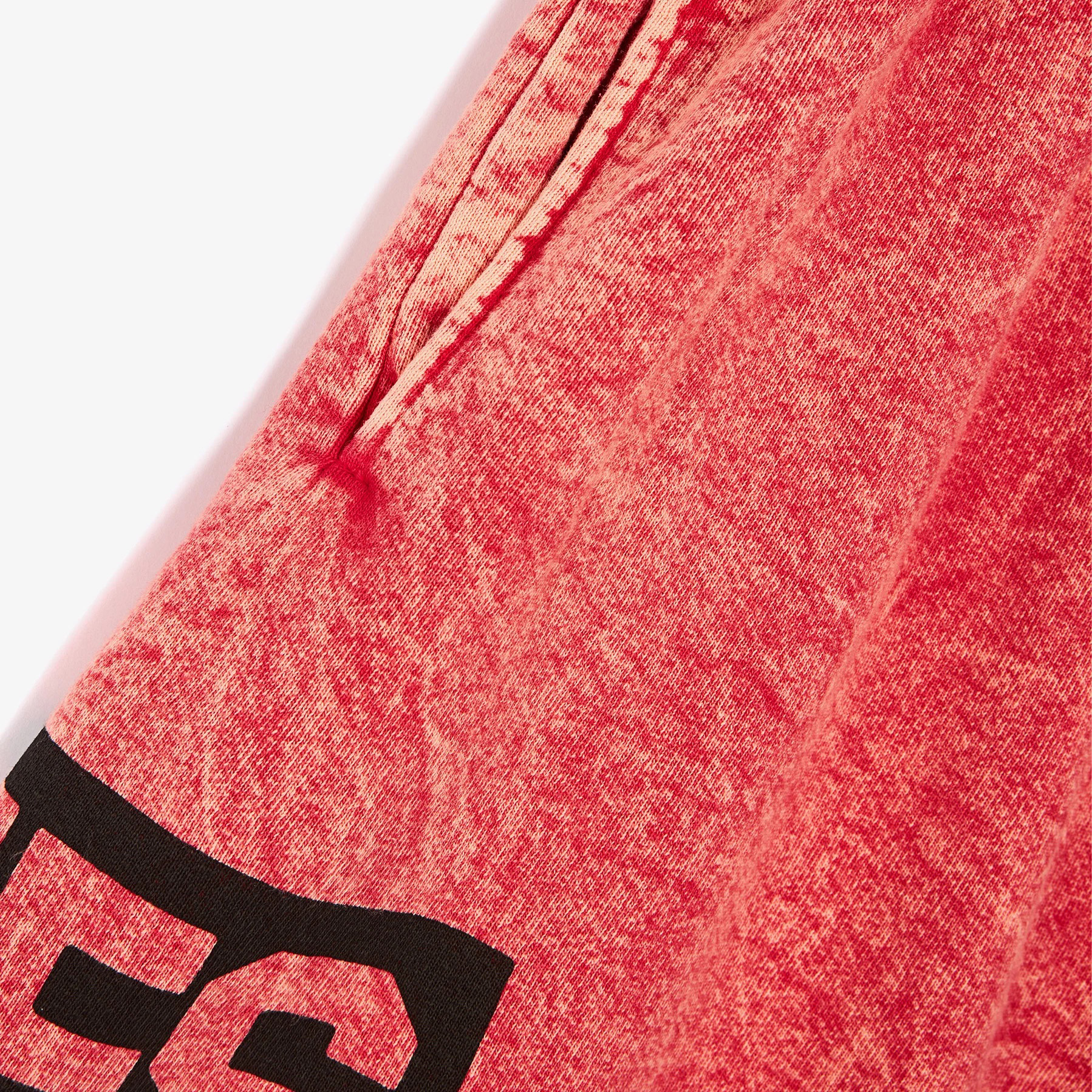 Tecido vermelho com textura desgastada e impressão preta parcial