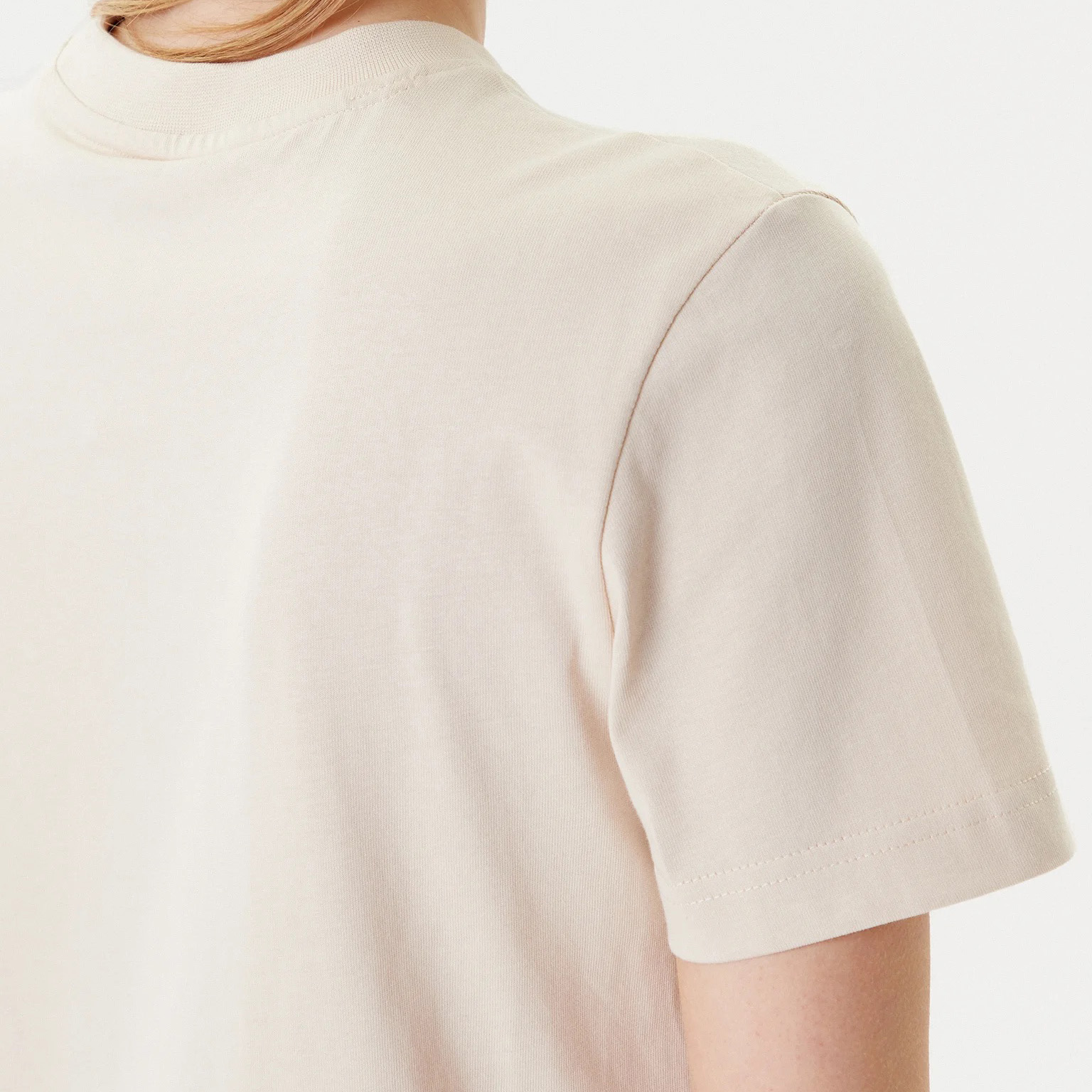 T-shirt bege clara de algodão vista de perto no ombro e manga com gola redonda