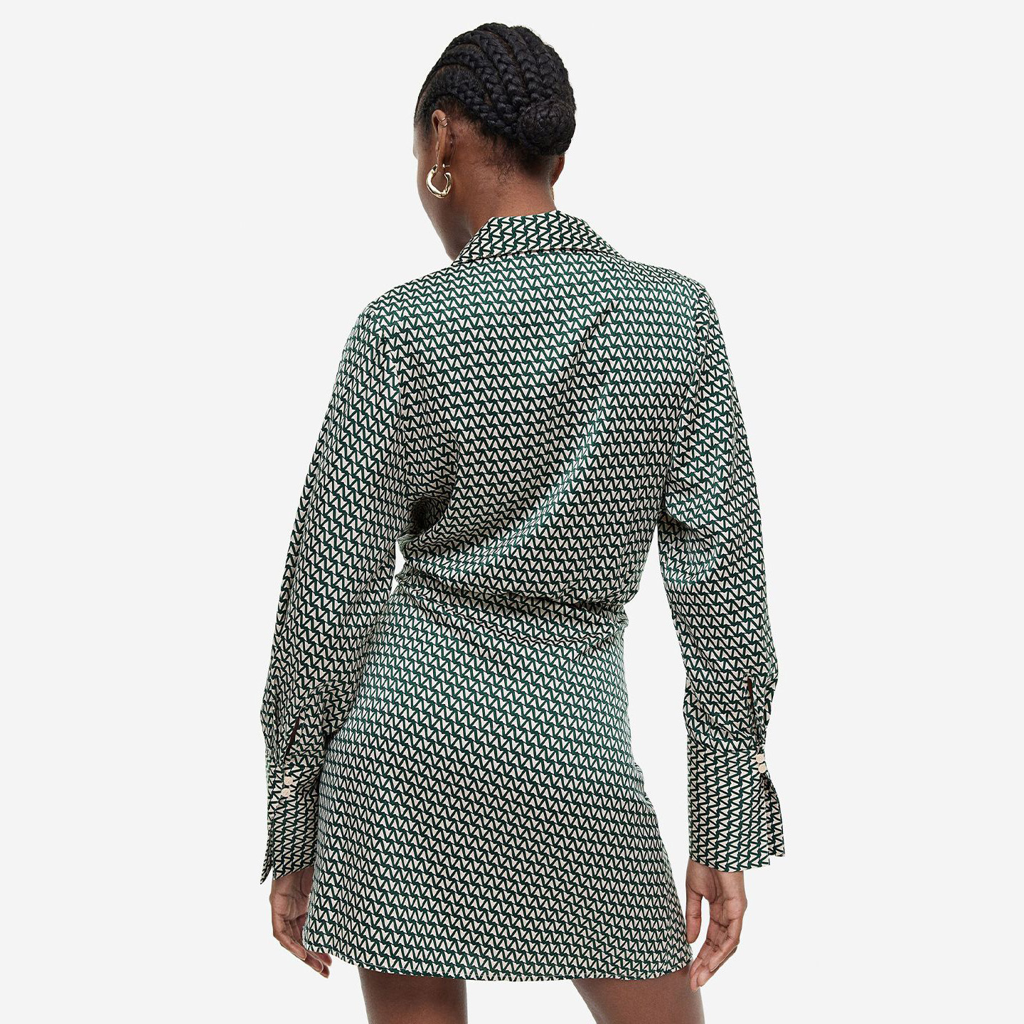 Vestido curto com padrão geométrico verde e branco visto por trás.