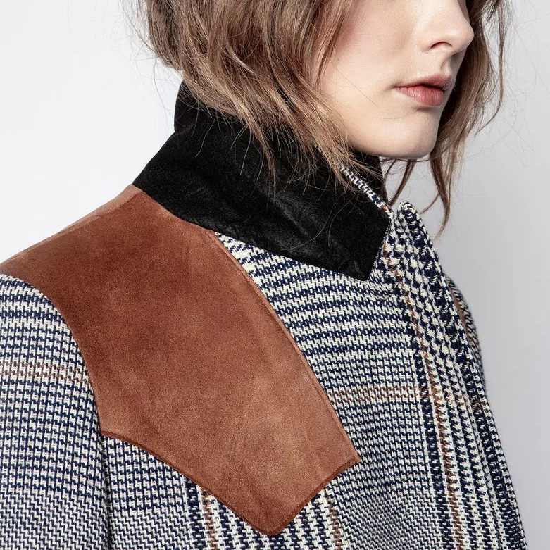 Casaco pied-de-poule com gola preta e couro castanho no ombro.