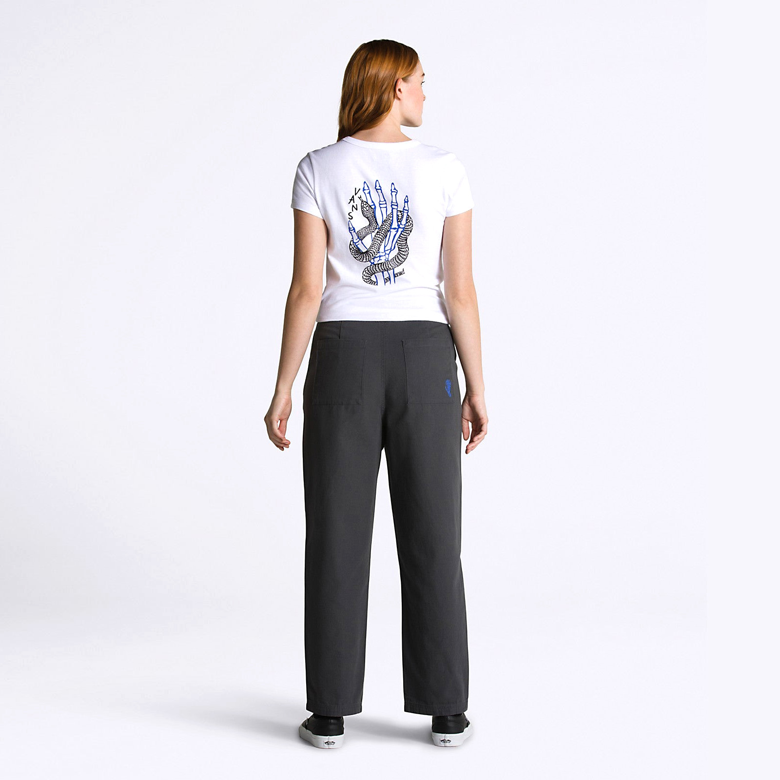 Mulher vista de costas com t-shirt branca estampada e calças pretas