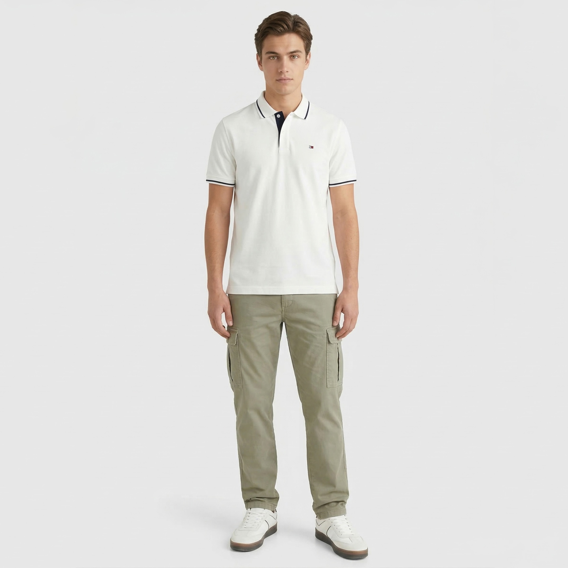 Homem com polo branca, calças cargo verde claro e ténis brancos.