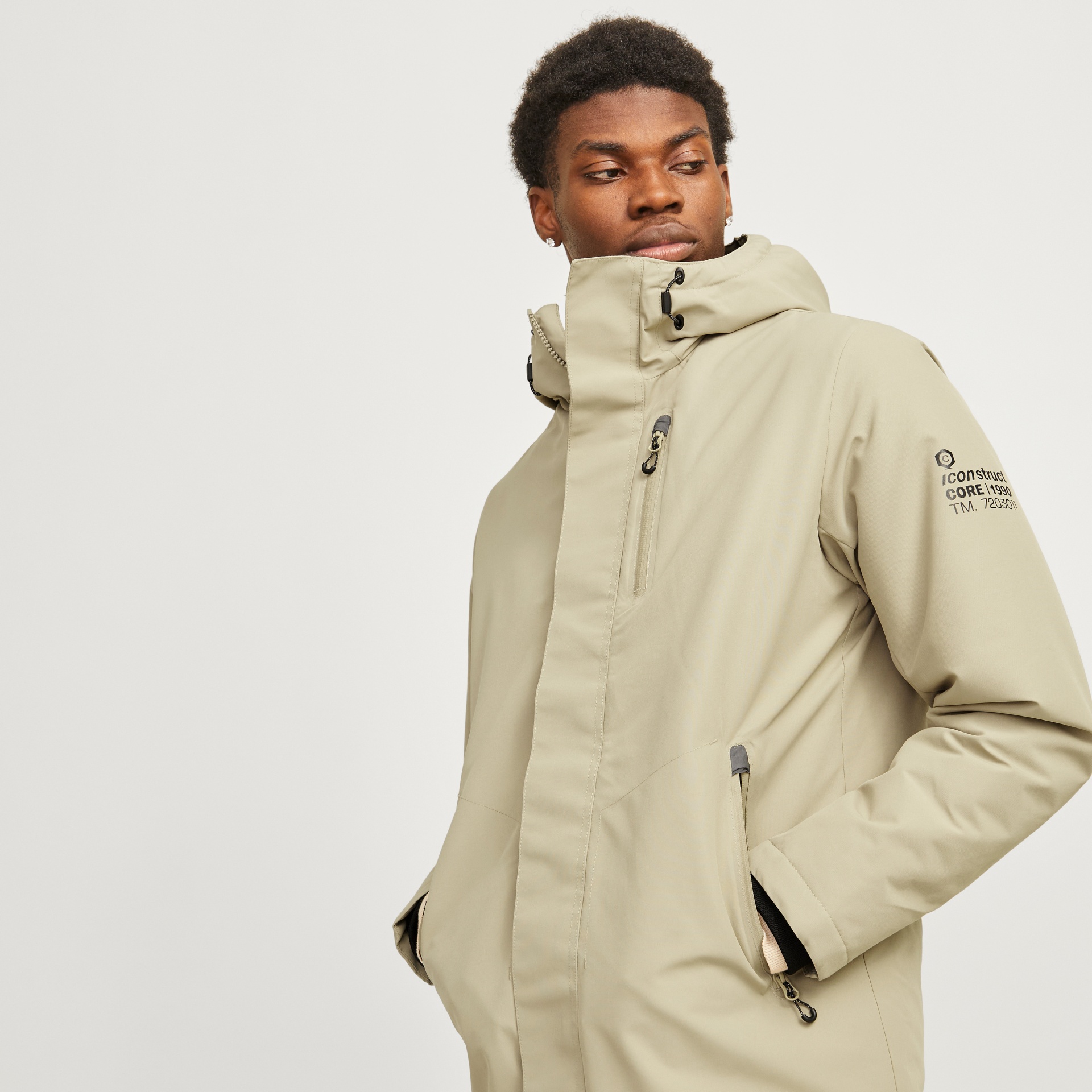 Casaco bege com capuz e bolsos, texto no braço direito