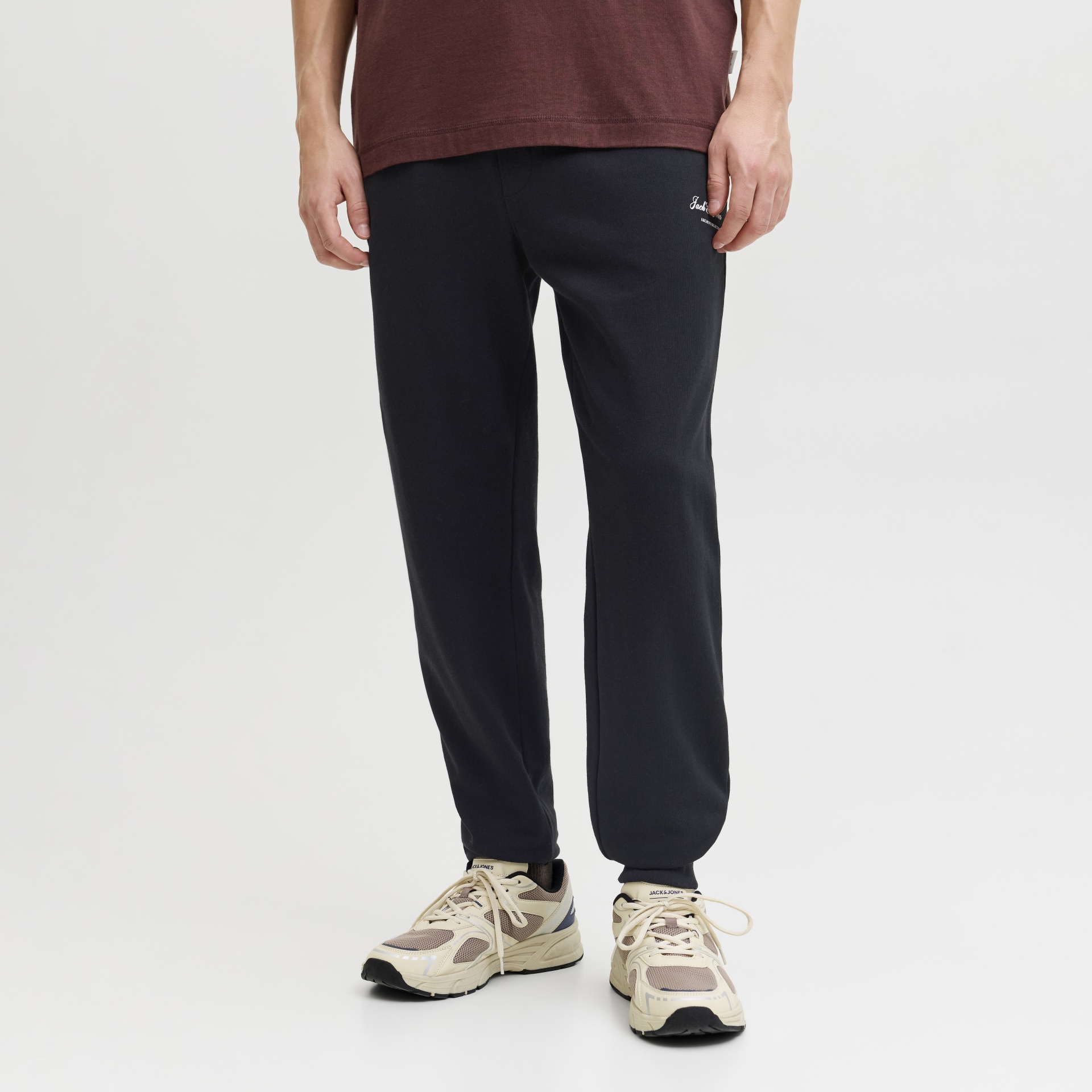 Calças de fato de treino pretas com texto Jack & Jones e ténis bege