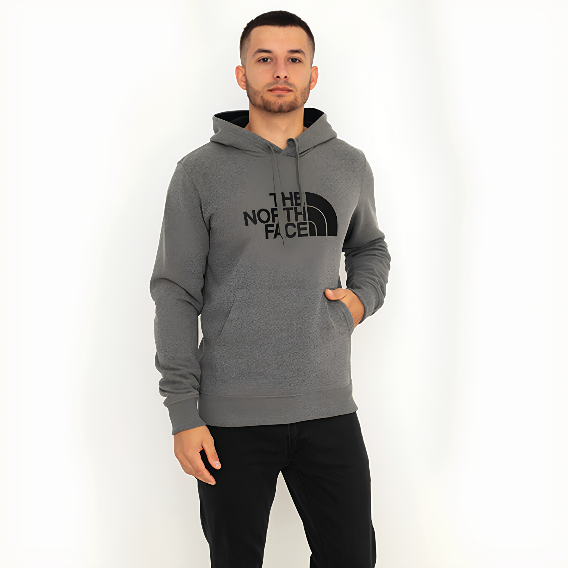 Homem com hoodie cinzento The North Face e calças pretas em fundo branco