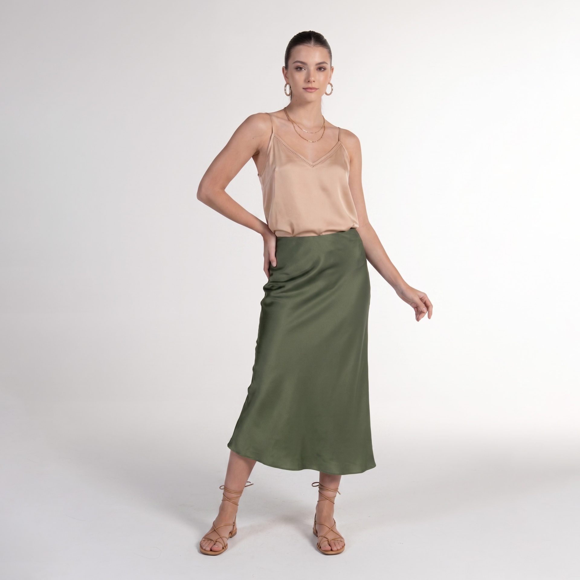 Mulher com regata bege e saia verde