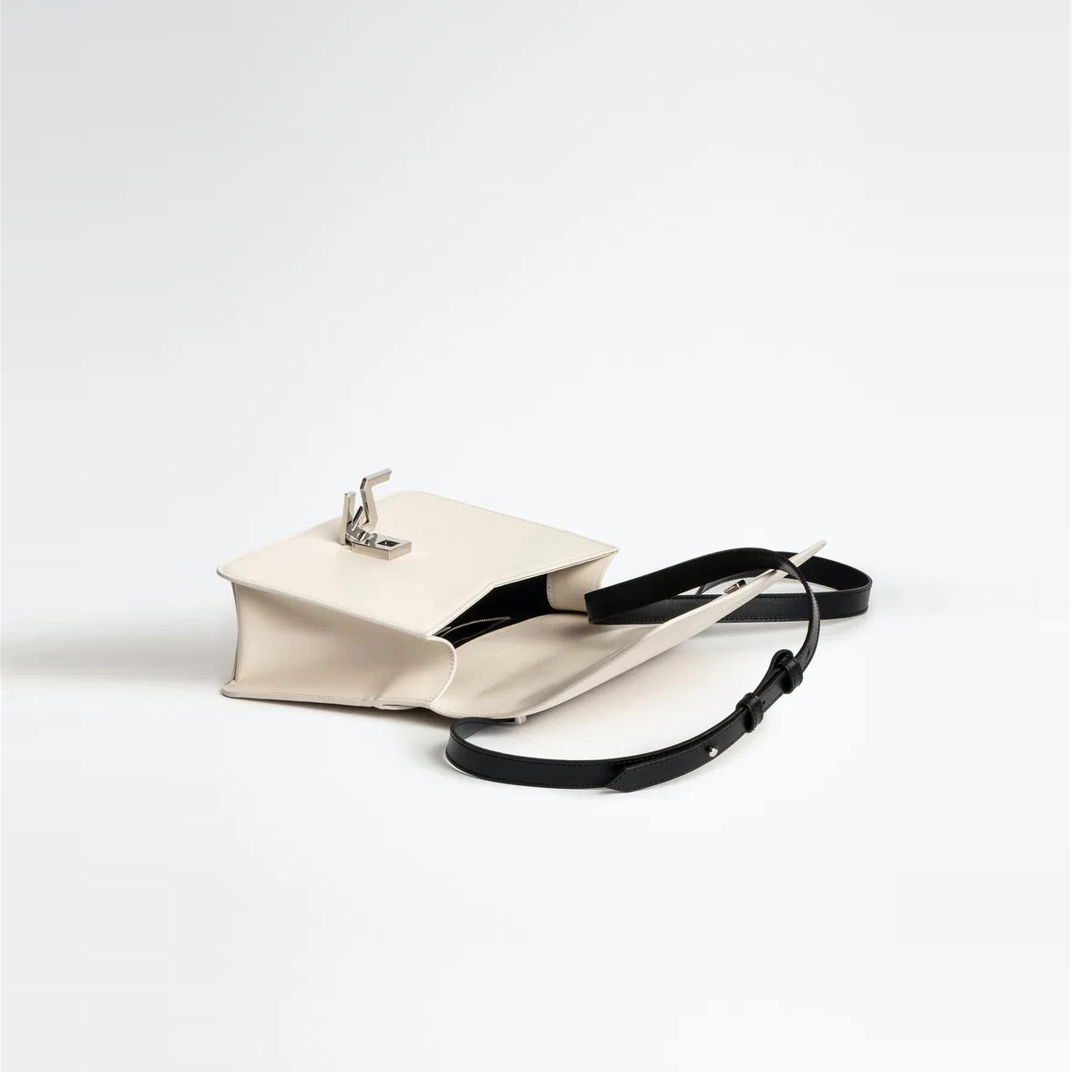Mala tipo envelope bege com alça preta e fecho metálico aberta