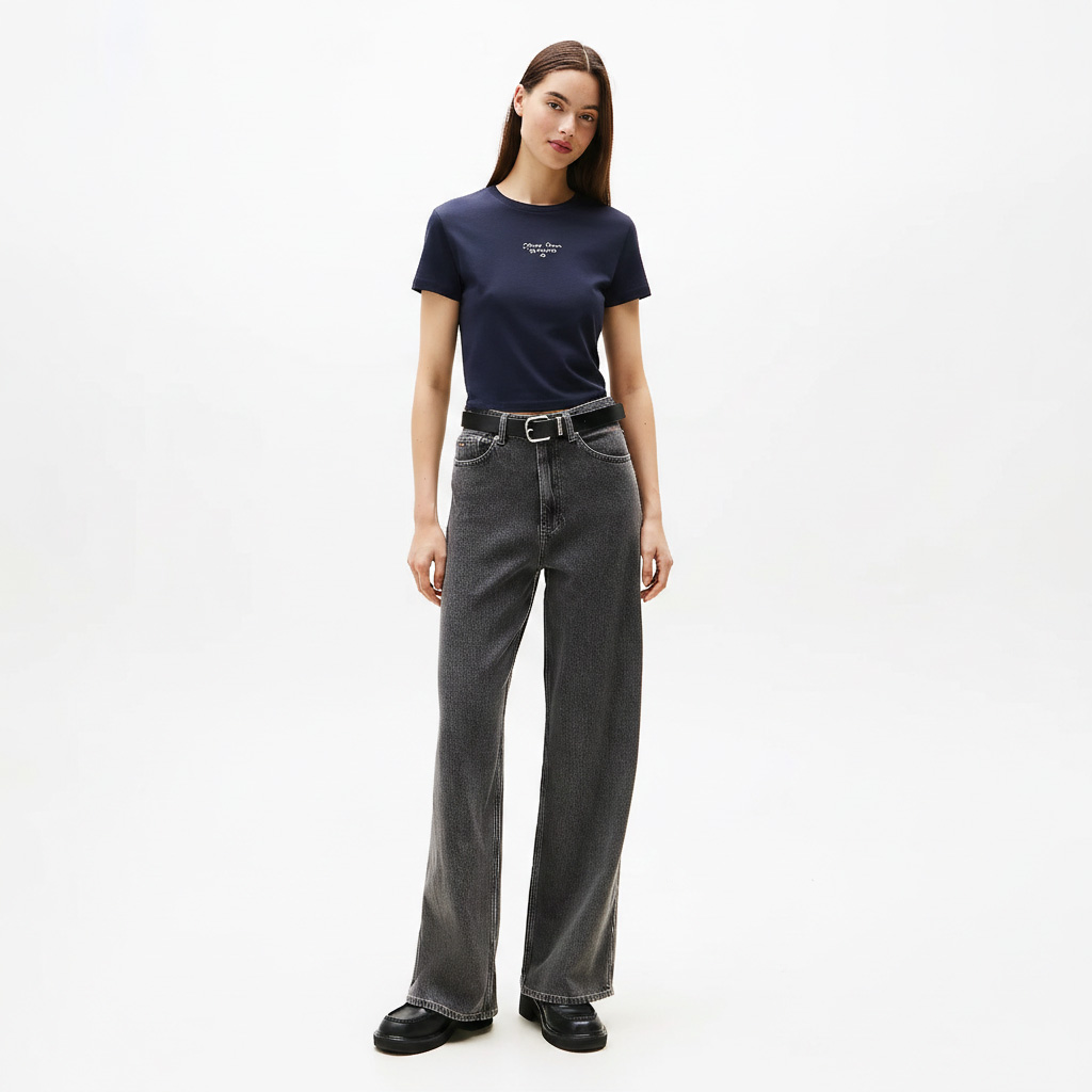 Mulher a vestir t-shirt azul escura com texto SLOW e calças jeans cinzentas largas.