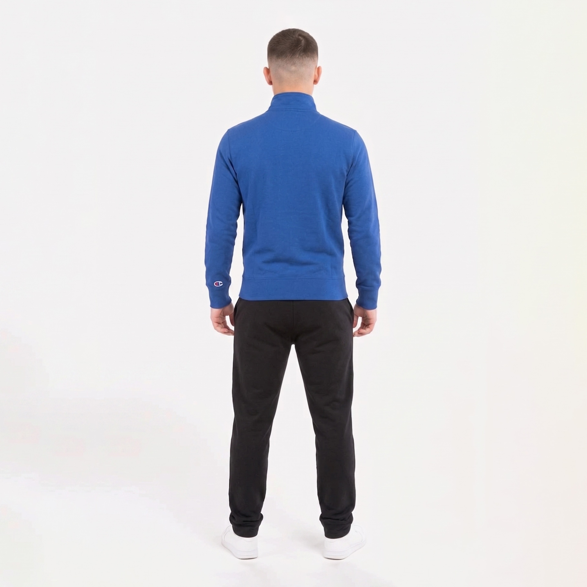 Homem visto de costas a usar sweatshirt azul com gola alta e logo na manga