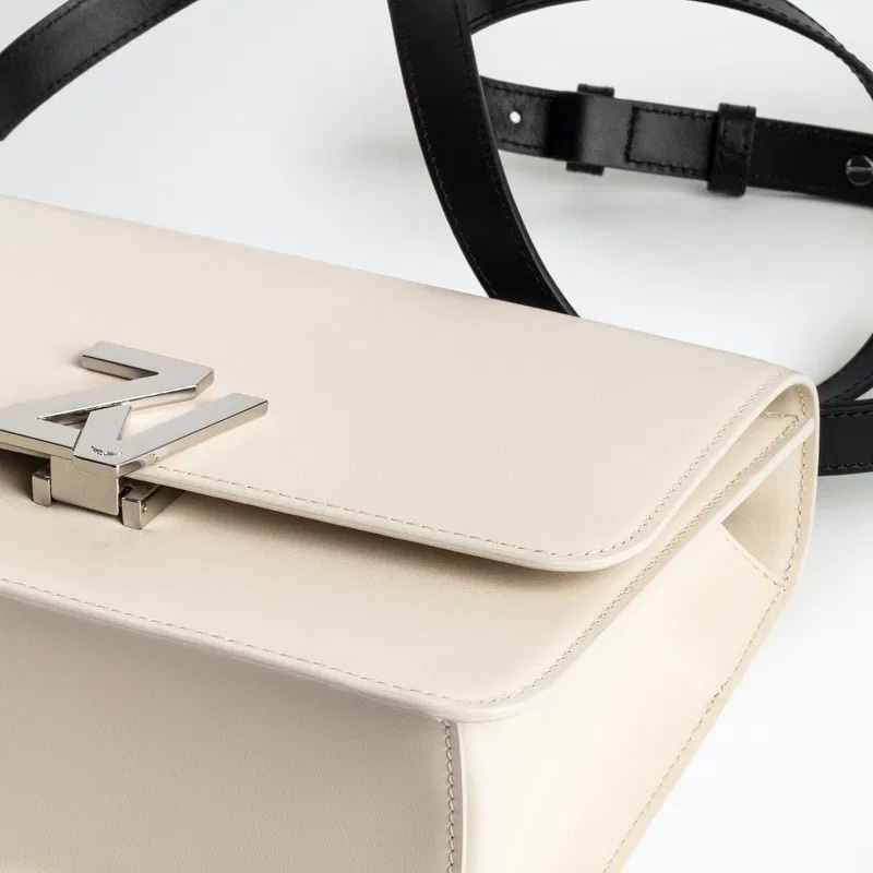 Mala de senhora bege com fecho metálico prateado e correia preta