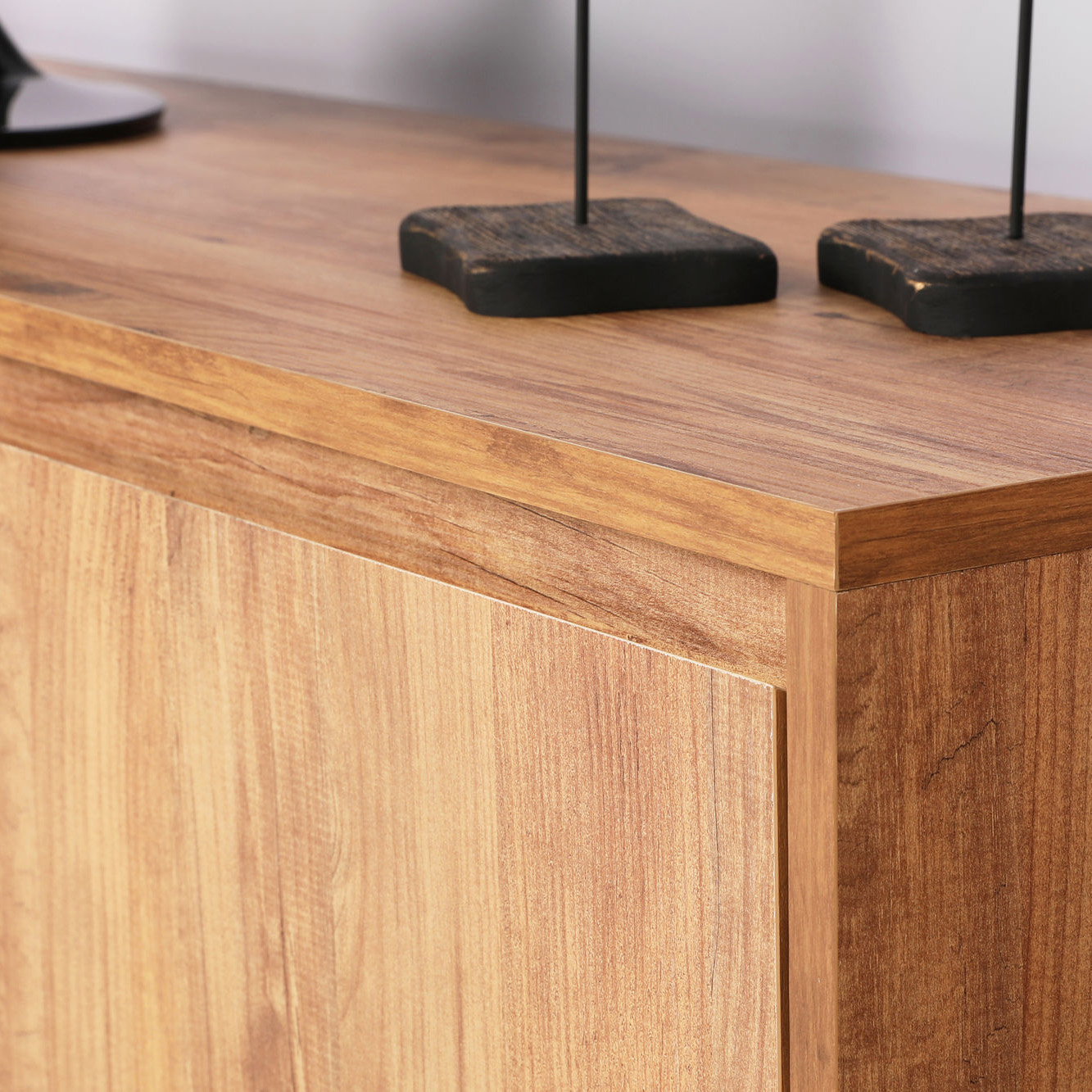 Móvel de madeira clara com suportes pretos de madeira e metal no tampo