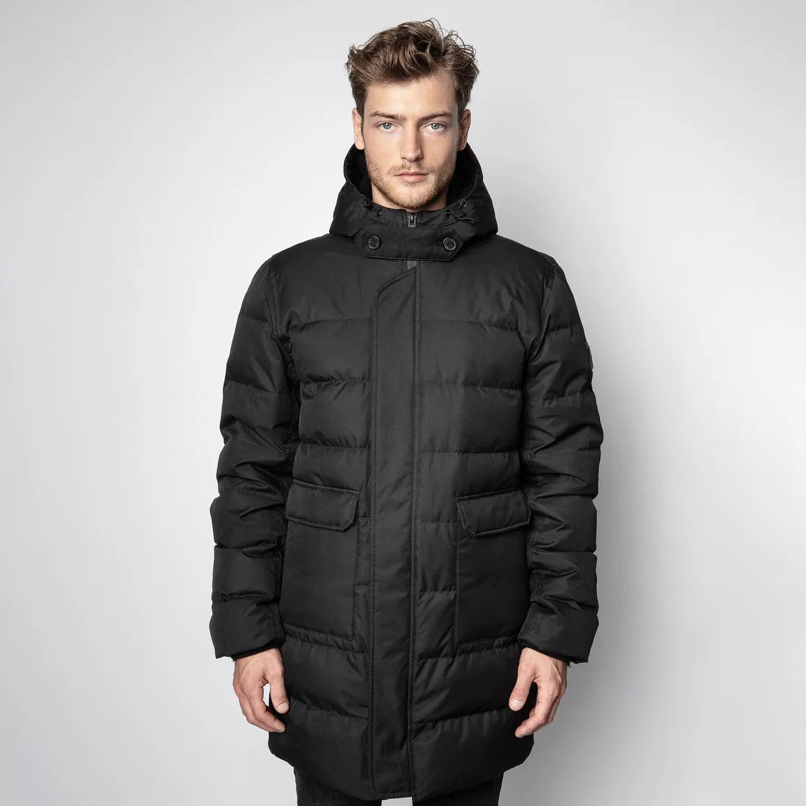 Homem com casaco comprido acolchoado preto com capuz