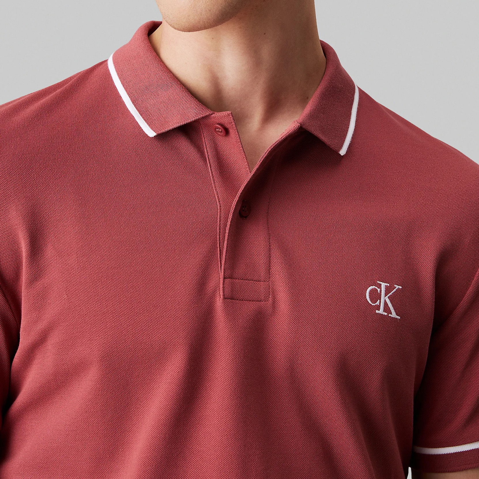 Polo de homem cor tijolo com gola e mangas com detalhes brancos e logótipo cK bordado