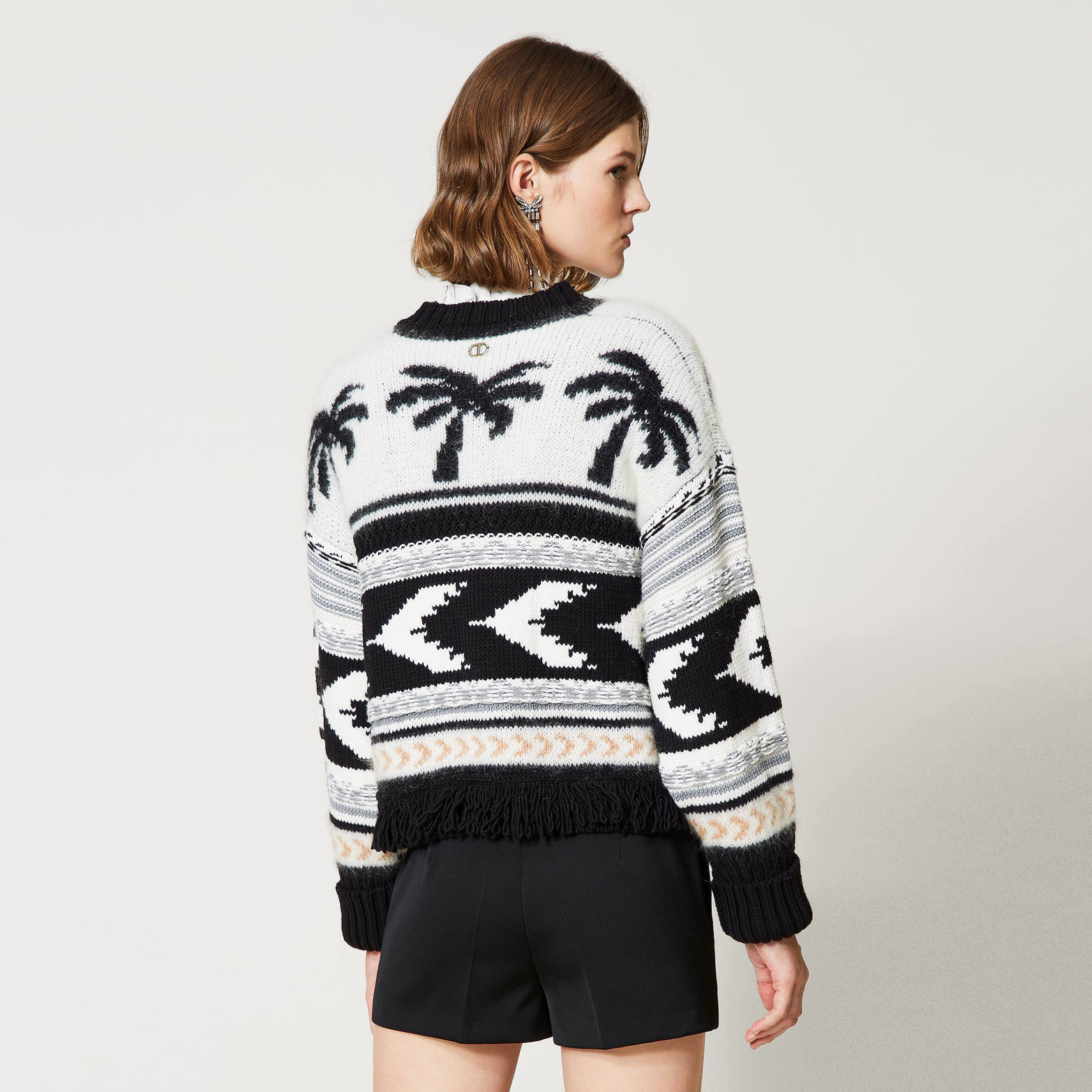 Camisola de malha com padrão preto e branco e palmeiras vista de costas