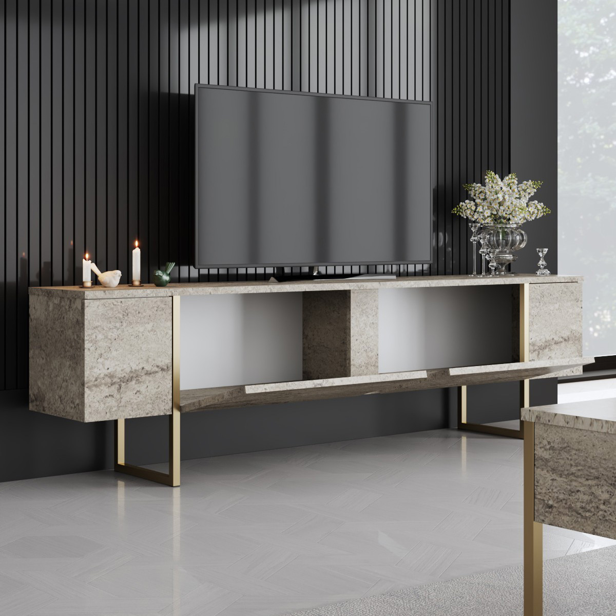 Móvel televisão cinzento mármore com detalhes dourados e decoração com velas e flores.