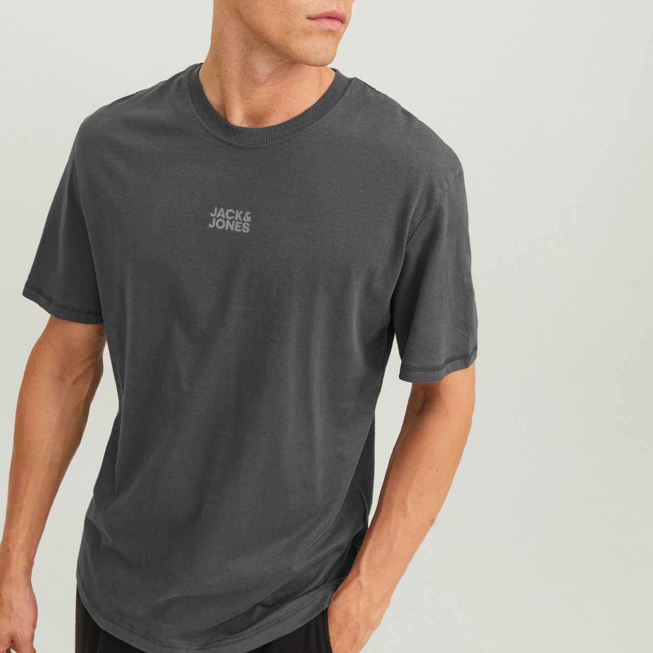 T-shirt cinzenta escura com texto JACK & JONES branco no centro em modelo