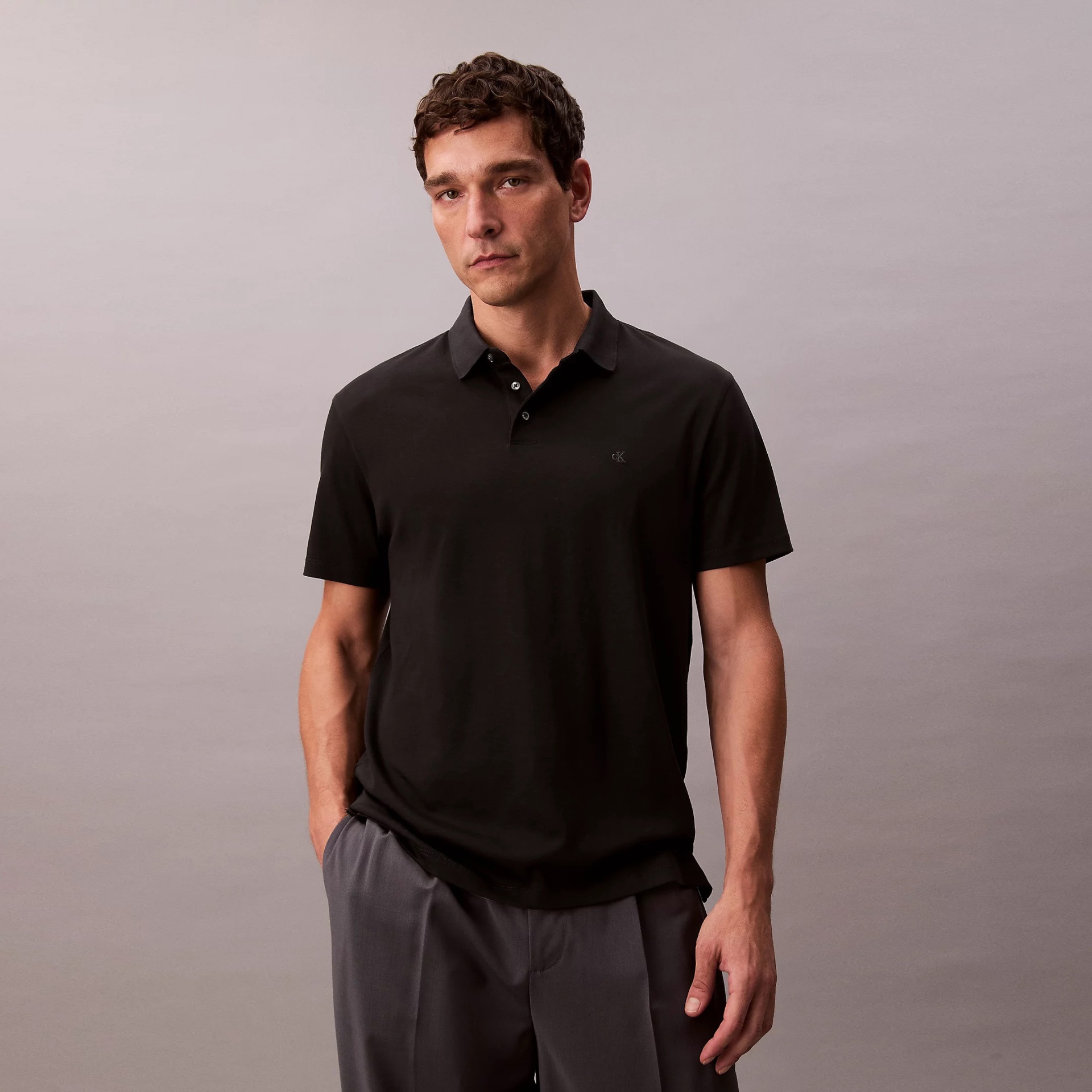Homem a vestir polo preta cK de manga curta