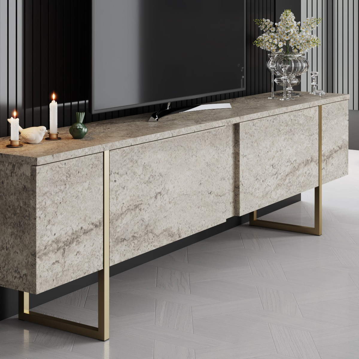 Móvel de apoio de TV em pedra cinzenta com estrutura dourada decorado com velas, objeto decorativo e jarra com flores brancas