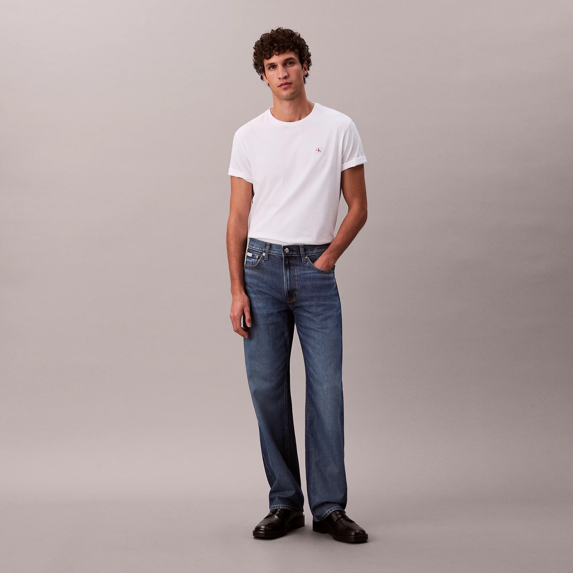 Homem com t-shirt branca e jeans azuis jeans