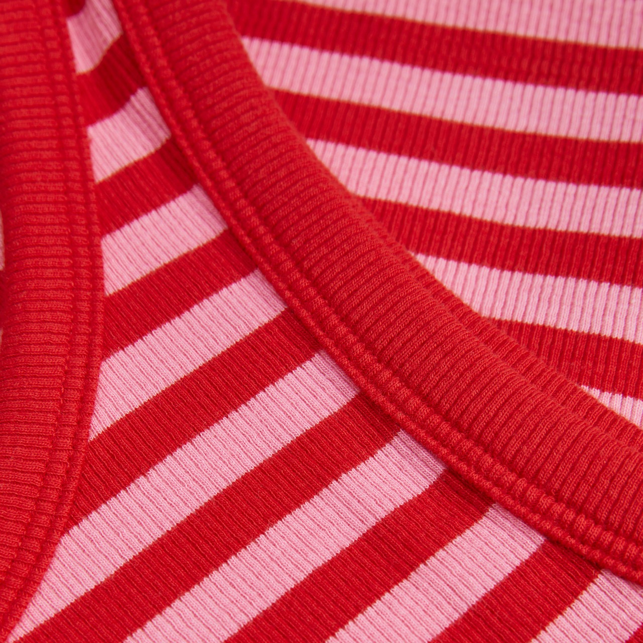 tecido de malha às riscas vermelhas e rosas com acabamento vermelho na borda